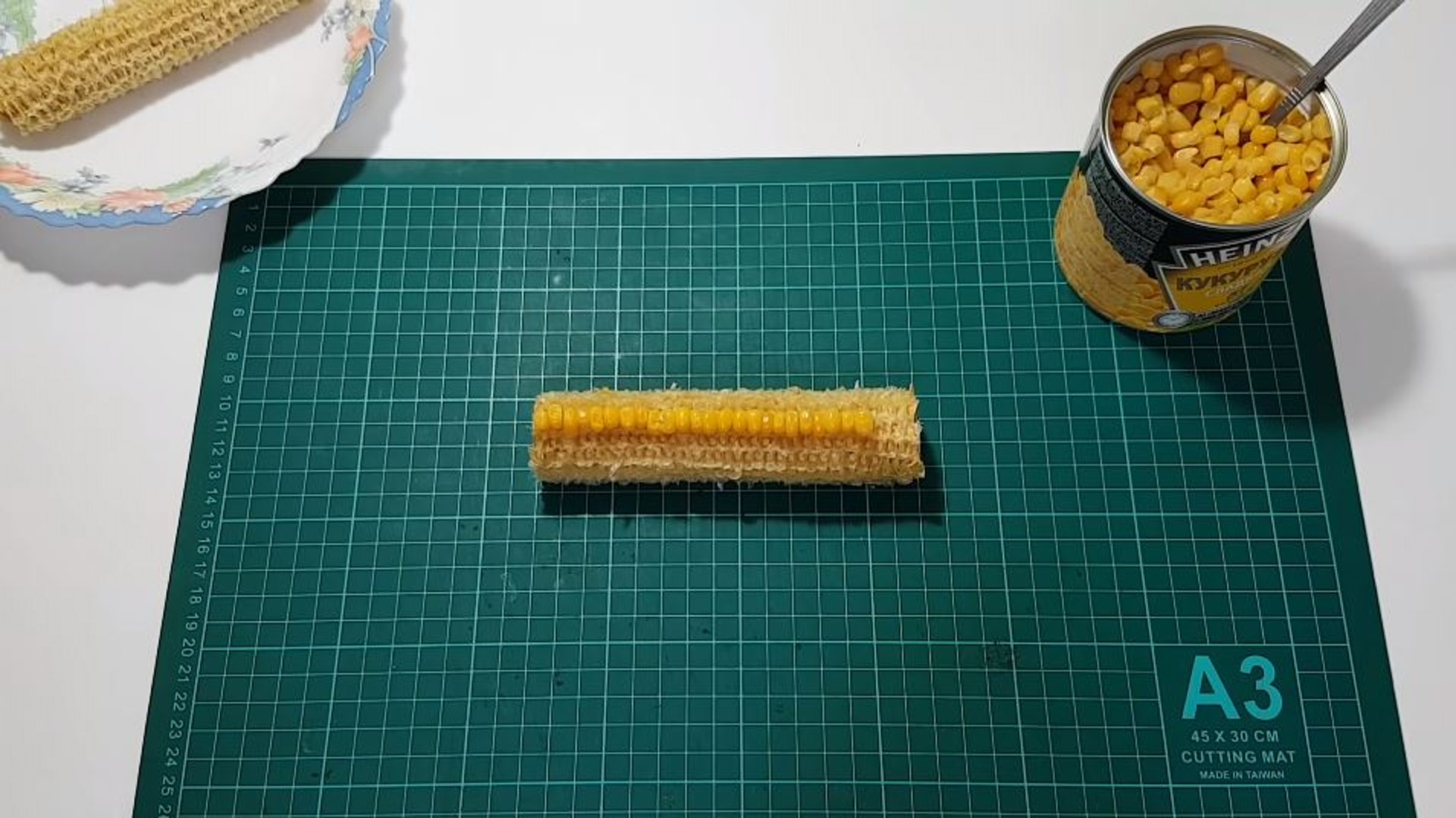 影片中,Curiosityandbeyond先從冰箱拿出兩根被啃光的粟米梗,長度約15公分左右,再打開一罐粟米罐頭,將罐內的粟米粒,一顆一顆依序地放回粟米梗上的凹槽。(影片截圖) 影片中,Curiosityandbeyond先從冰箱拿出兩根被啃光的粟米梗,長度約15公分左右,再打開一罐粟米罐頭,將罐內的粟米粒,一顆一顆依序地放回粟米梗上的凹槽。(影片截圖)