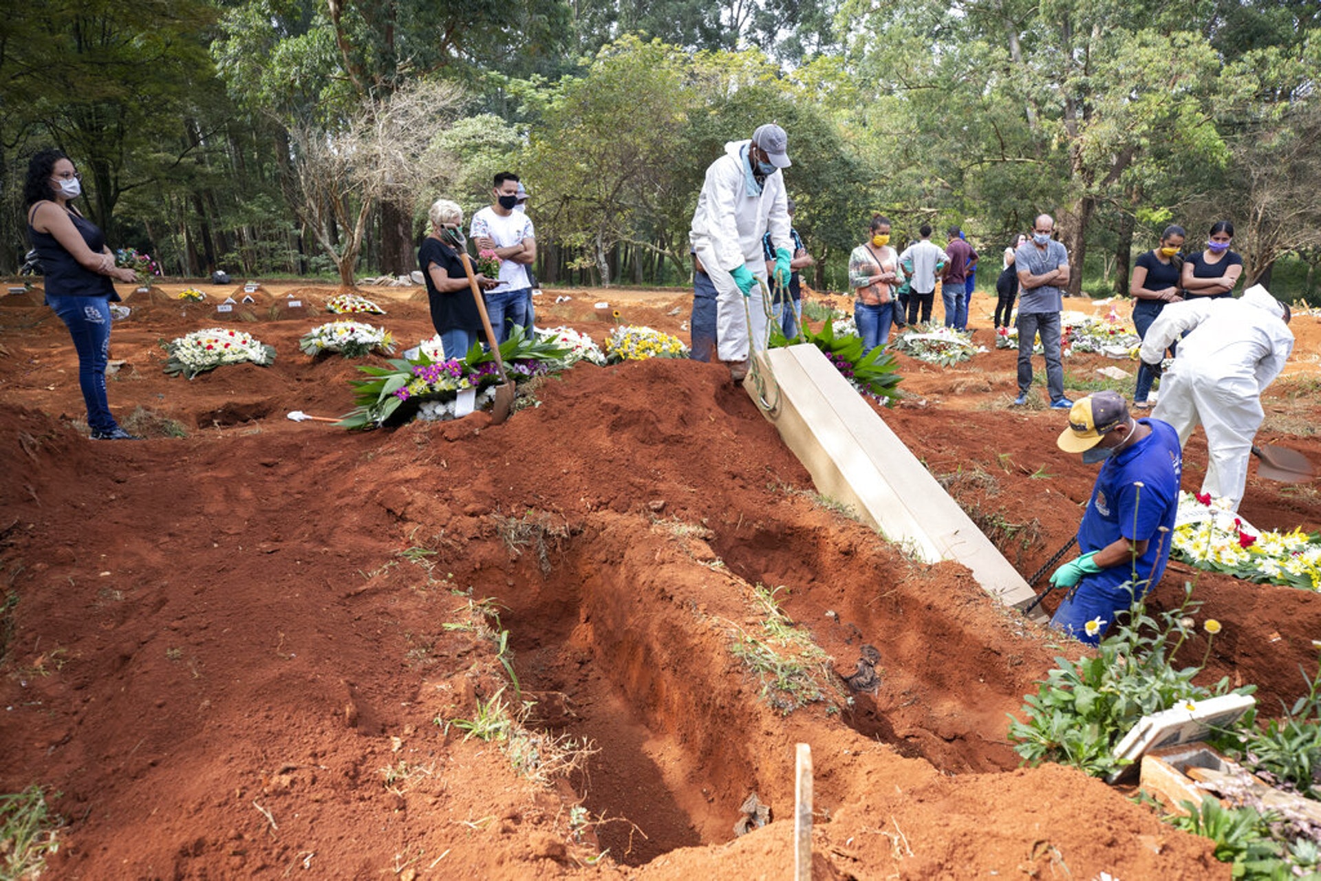 巴西新冠肺炎疫情:圖為4月30日巴西聖保羅Vila Formosa公墓的工作人員將一副棺材放在墓穴中。(AP)