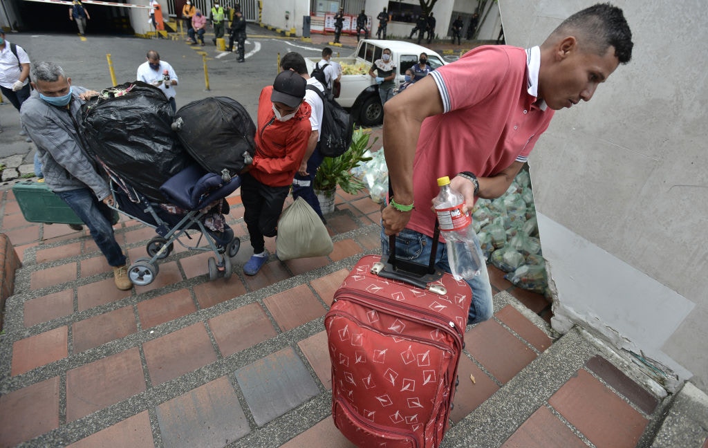 4月14日，哥倫比亞卡利，委內瑞拉移民背著行李登上將送他們回國的大巴車。（Getty）