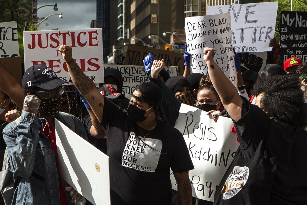 加拿大多倫多一名非裔女子5月27日在家中離奇墮樓，引發民眾上街示威。她的母親事前為女兒召警，想他們去協助極度憂傷的女兒。加拿大有人認為警方處理精神不穩者個案，最後不時以死亡收場，情況不能再出現。圖為5月30日，示威者在多倫多市中心示威。（AP）