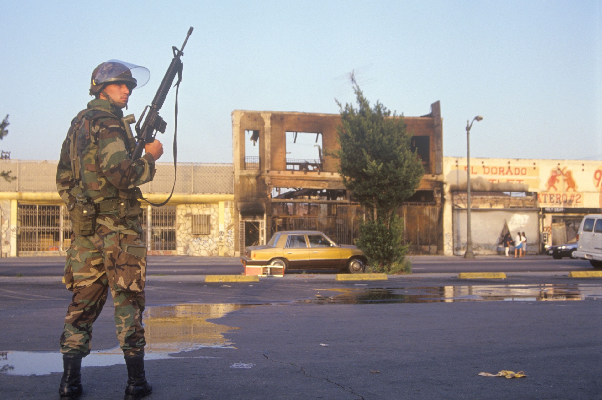 1992年洛杉機發生暴動,多個建築物被縱火及多人被殺,政府決定派出軍隊鎮壓。圖為1992年洛杉機,軍隊正在街上戒備巡邏。(Getty) 1992年洛杉機發生暴動,多個建築物被縱火及多人被殺,政府決定派出軍隊鎮壓。圖為1992年洛杉機,軍隊正在街上戒備巡邏。(Getty)
