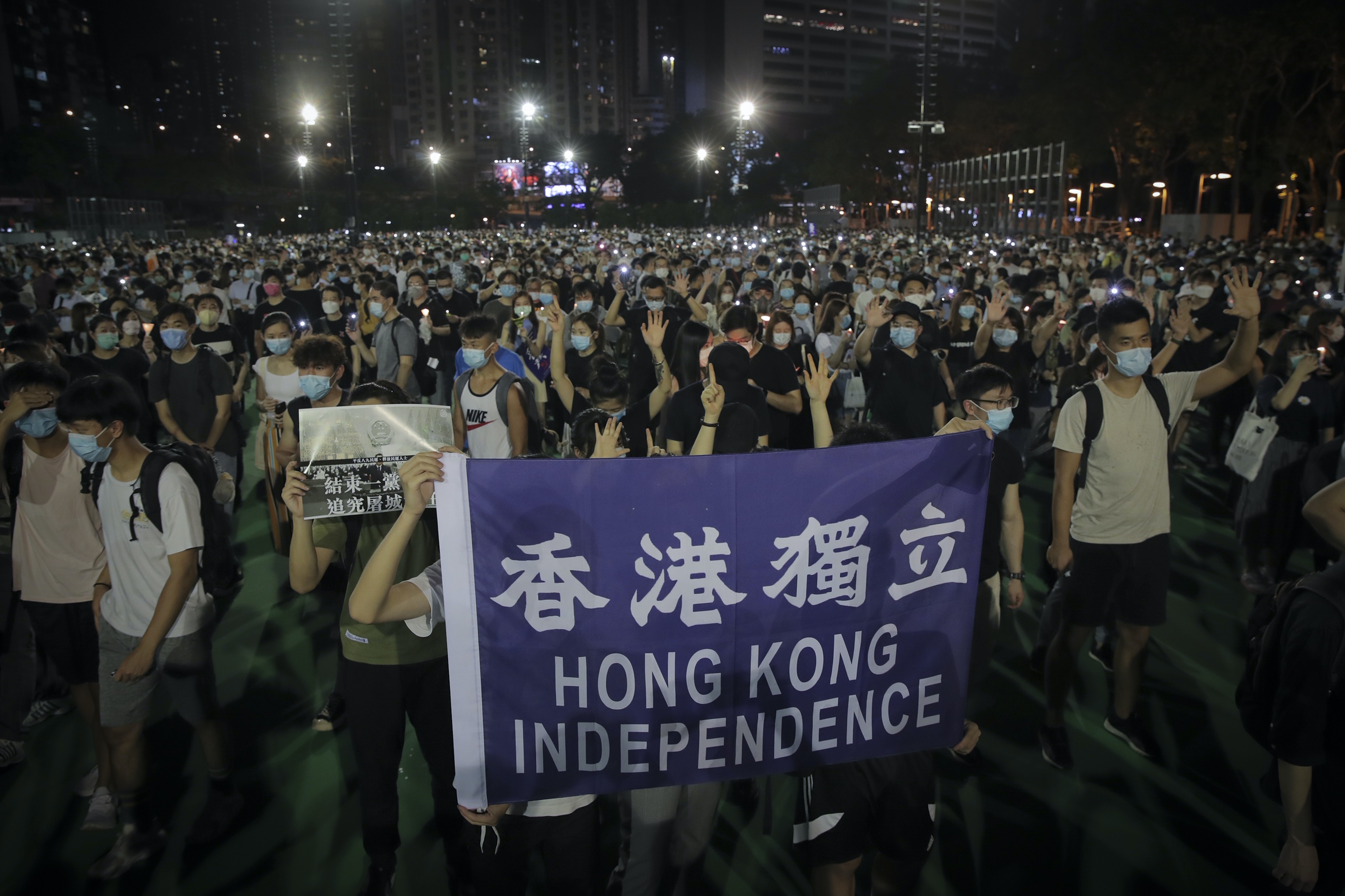 六四31：圖為6月4日，香港大批市民在限聚令下依然前往維園出席六四晚會，人舉起「香港獨立」的旗幟。（AP）