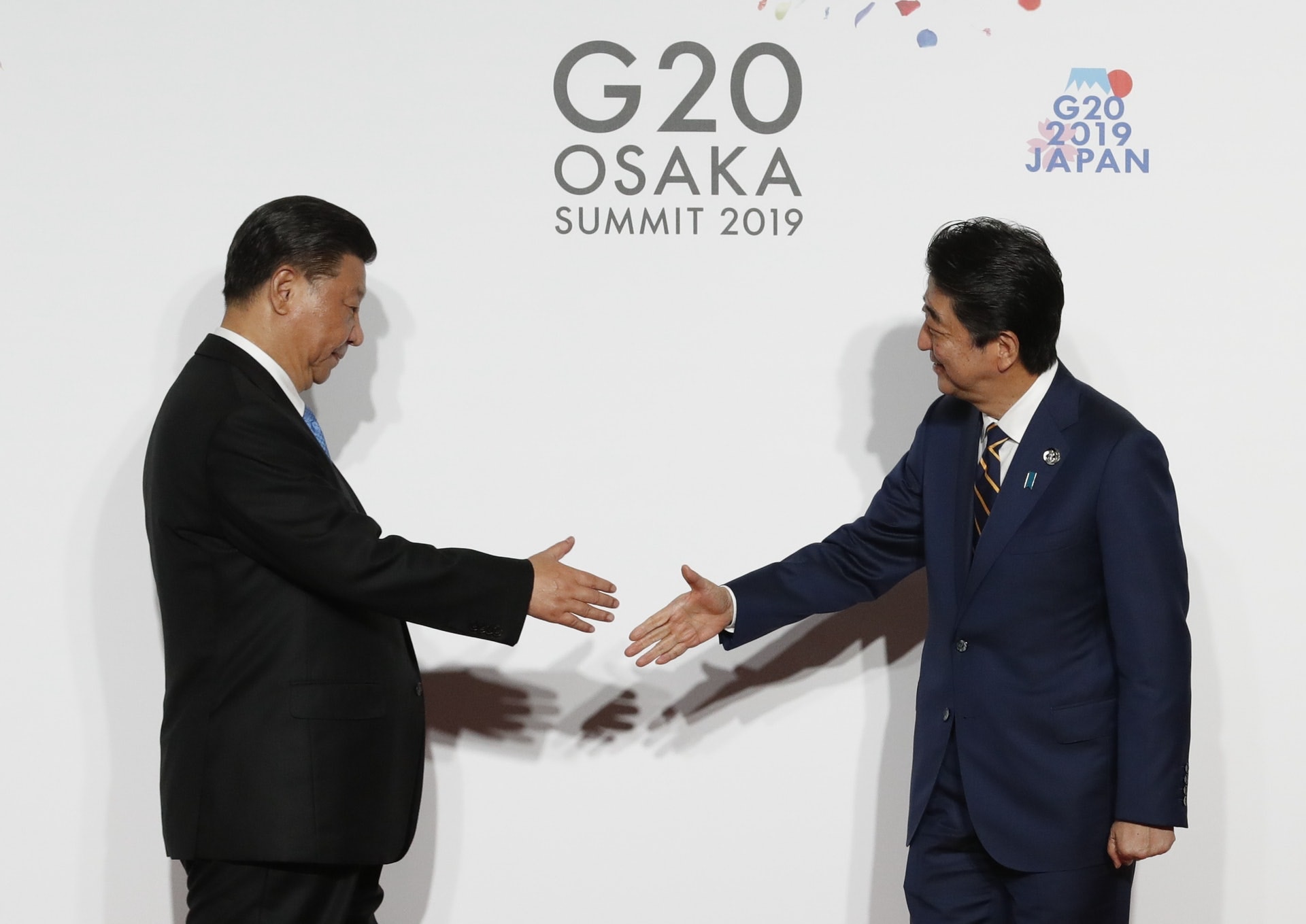 圖為中國國家主席習近平和日本首相安倍晉三2019年6月28日在出席二十國峰會時握手。（Getty Images）