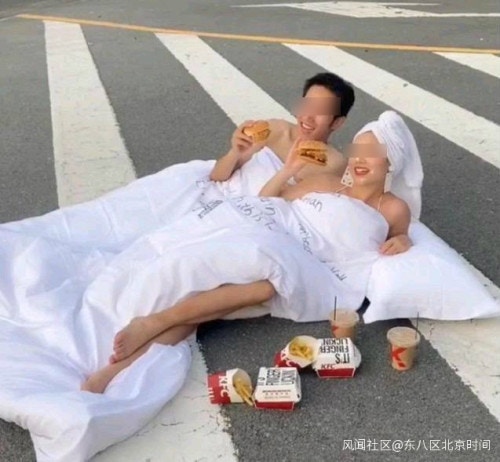 近日山東一對新人躺在馬路上拍「婚紗照」，兩人半裸僅裹著床單。（網絡圖片）