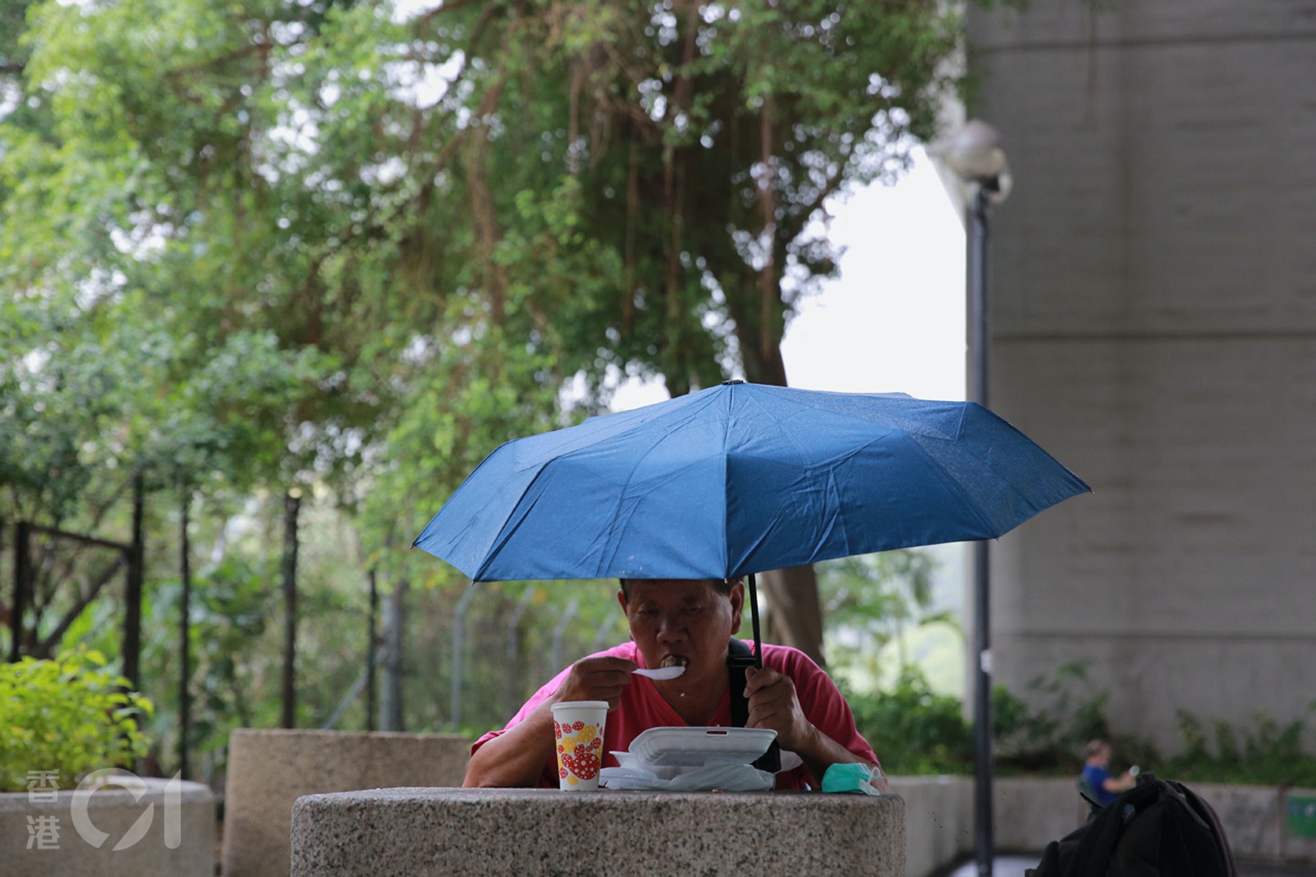 巿民手持雨傘,在荃灣一個公園食午飯。(羅國輝攝) 巿民手持雨傘,在荃灣一個公園食午飯。(羅國輝攝)