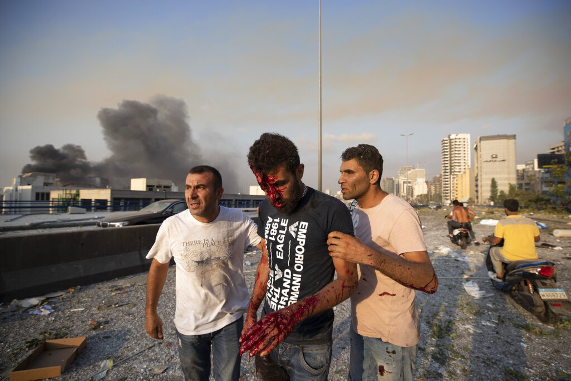 黎巴嫩貝魯特爆炸:圖為8月4日一名男子在爆炸發生後協助另一名傷者。(AP)