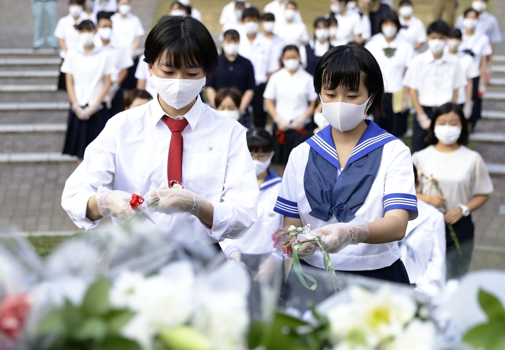 長崎原爆:日本長崎市8月9日舉行原爆75周年和平紀念儀式,戴上口罩的學校為原爆死難者獻花。(Reuters) 長崎原爆:日本長崎市8月9日舉行原爆75周年和平紀念儀式,戴上口罩的學校為原爆死難者獻花。(Reuters)