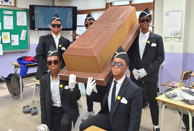 韓國有高中生以「黑人抬棺」的造型拍攝畢業相，後來被批評塗黑臉舉動冒犯黑人。（fb圖片）