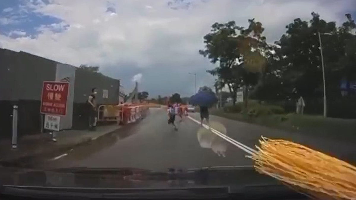 近日一段車cam片段在網上流傳，只見有家長帶一名女童橫過馬路，並在雙程路中間停留，當車子駛近時，女童突然折返衝回行人路上，幸好車主及時剎車才沒有造成意外。（影片截圖）