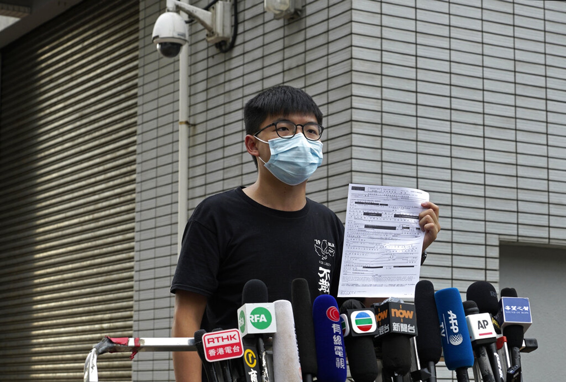 圖為2020年9月24日,前香港眾志秘書長黃之鋒被捕,於警署外向傳媒展示保釋文件。(AP) 圖為2020年9月24日,前香港眾志秘書長黃之鋒被捕,於警署外向傳媒展示保釋文件。(AP)