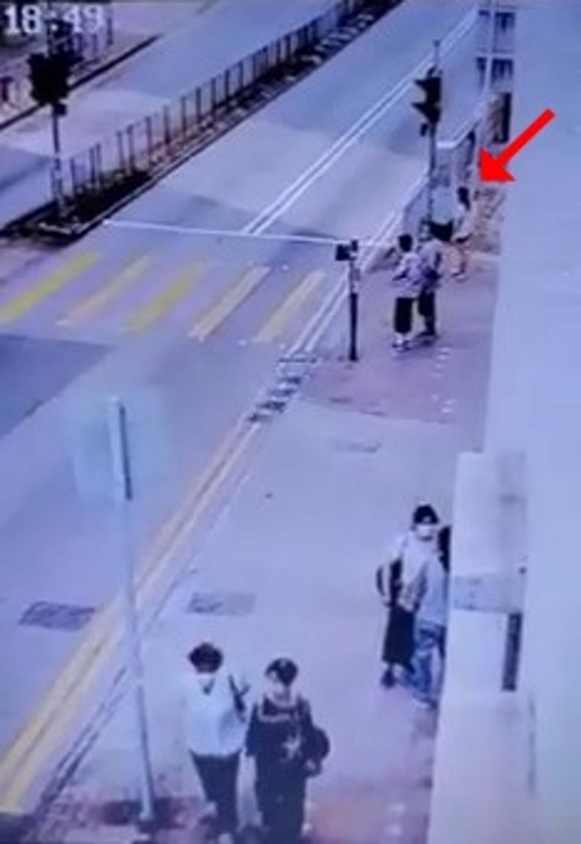 長髮女事主在燈位等候過路,當時尚有兩名途人一同等候。(網上影片截圖) 長髮女事主在燈位等候過路,當時尚有兩名途人一同等候。(網上影片截圖)