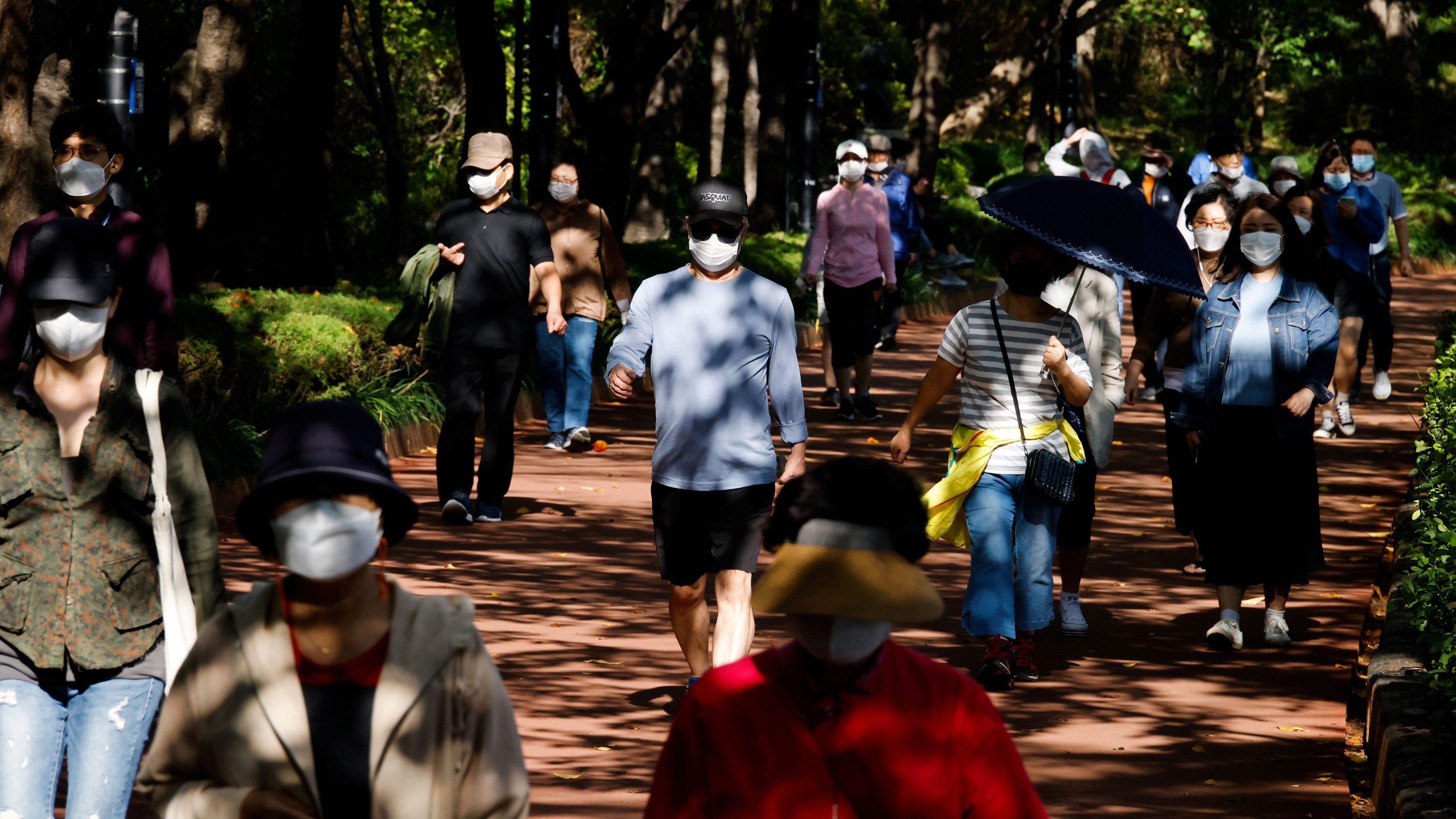 图为10月5日，途人戴上口罩在首尔公园散步。 （Reuters）