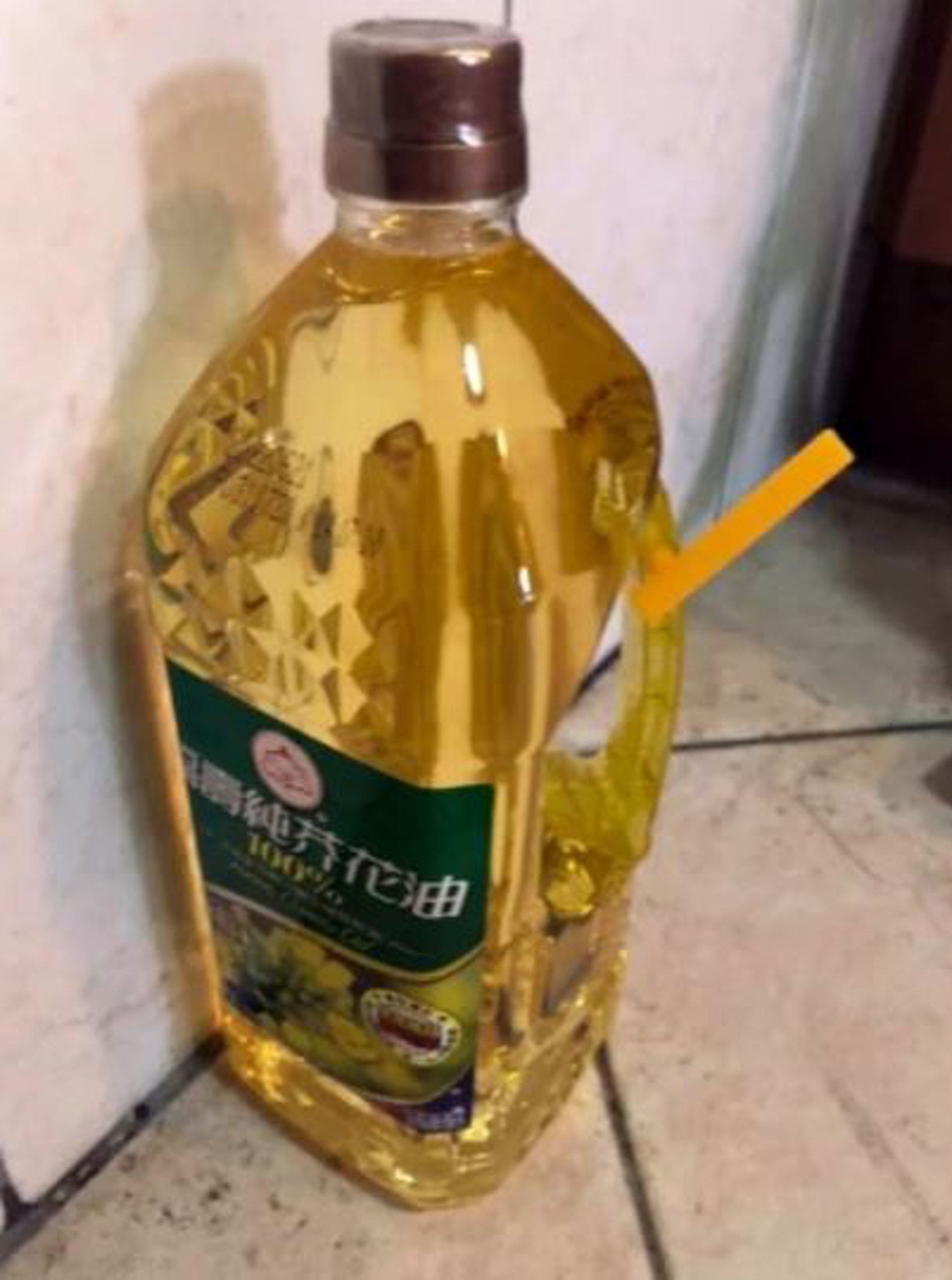 有網友發現全聯販售的一款葵花籽油把手上黏著一支黃色小管卻不知用途。（Facebook@我愛全聯－好物老實説）
