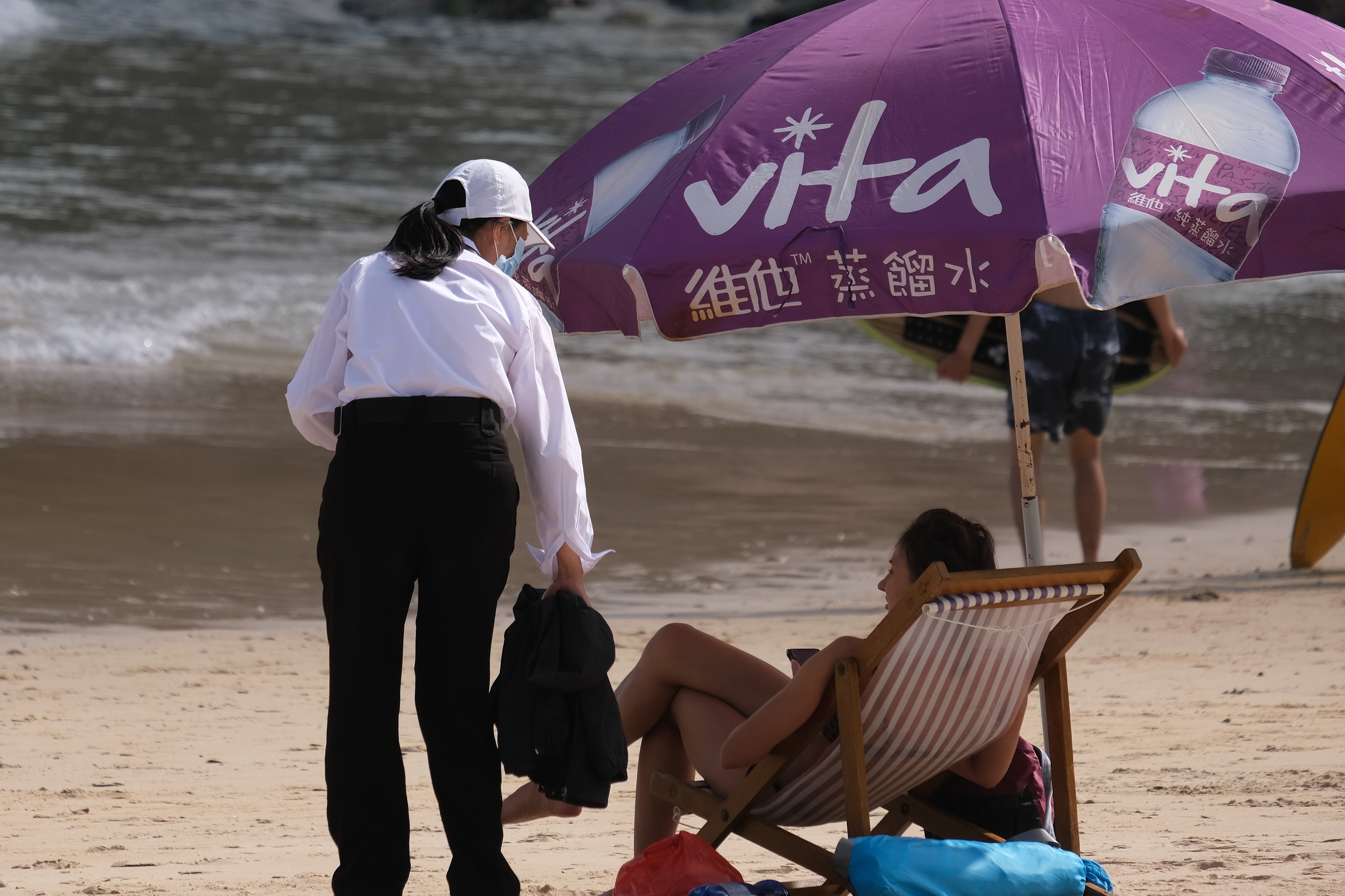 石澳泳灘有工作人員提醒泳客戴口罩，但不受理睬。（廖雁雄攝）