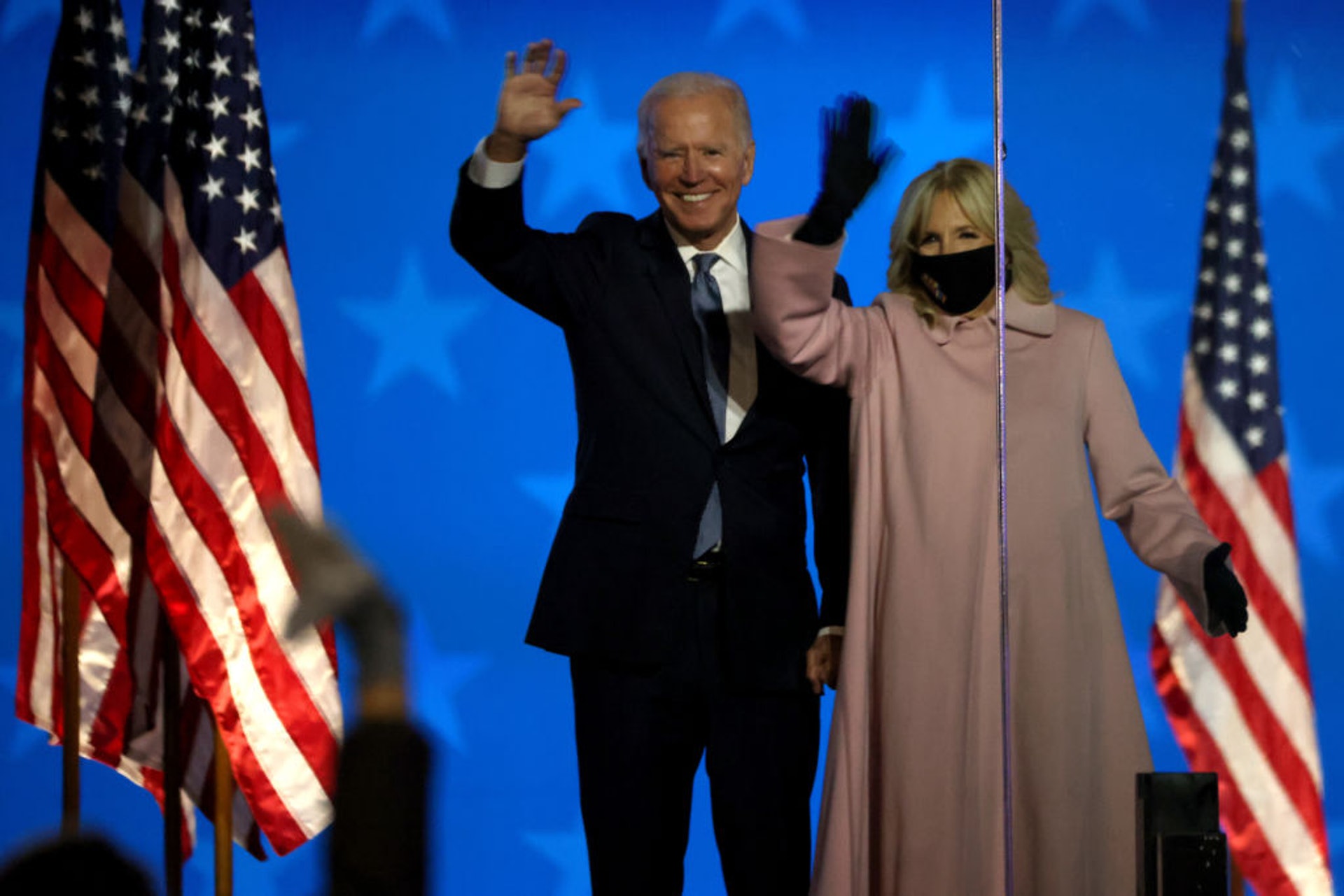美國大選2020：圖為吉爾11月4日在威爾明頓陪同拜登出席活動時，帶着印有彩色單詞的黑色口罩。英媒指，她選擇穿粉紅色西裝外套，是想透過口罩傳達訊息。（Getty）