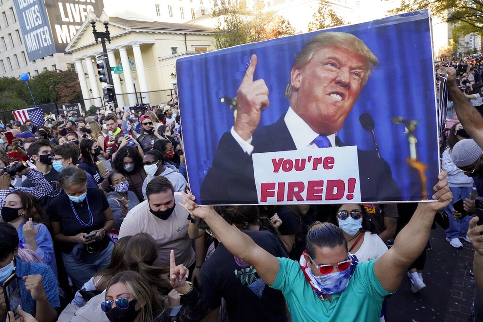 美國大選：圖為11月7日，拜登的支持者在華盛頓舉起標語牌，上面印有特朗普的肖像以及他在真人騷《飛黃騰達》中的名言「You're Fired」。(AP)