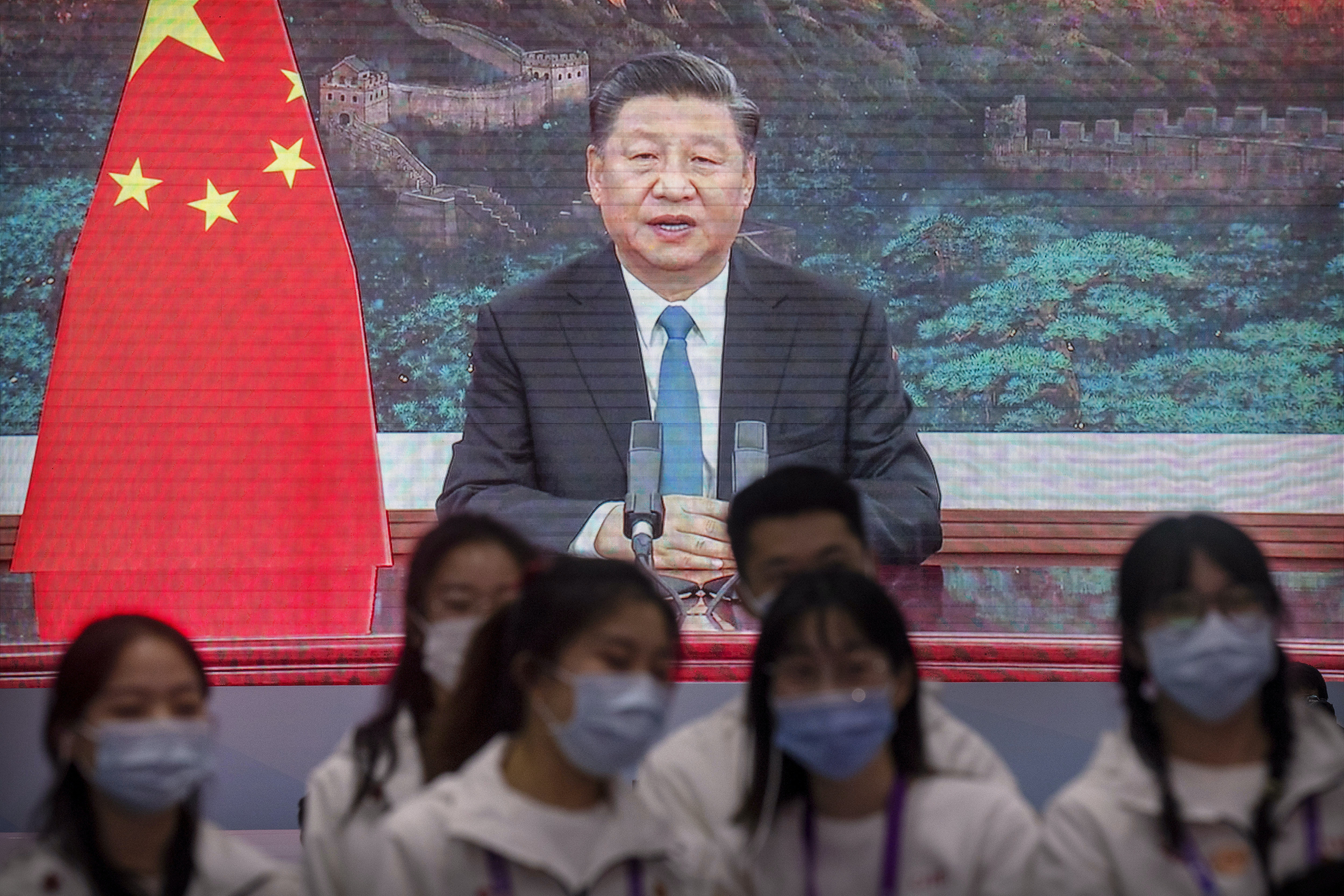 圖為11月4日中國國際進口博覽會的義工在上海透過熒幕觀看國家主席習近平為博覽會開幕禮致辭。（AP）