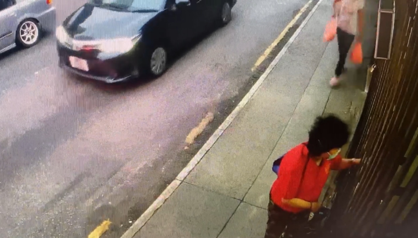 閉路電視片段顯示一名穿紅色上衣的婦人,大約下午5時19分時,在舖頭外徘徊,中途亦有人在玩貓及拍照,當時舖頭已關上大閘。(Facebook@Maggie Lee) 閉路電視片段顯示一名穿紅色上衣的婦人,大約下午5時19分時,在舖頭外徘徊,中途亦有人在玩貓及拍照,當時舖頭已關上大閘。(Facebook@Maggie Lee)