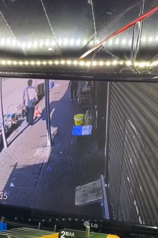 根據閉路電視片段,男子途徑建築材料公司,「可樂」於店外跳躍,男賊注意到「可樂」,其後折返將「可樂」抱走。(網上片段截圖) 根據閉路電視片段,男子途徑建築材料公司,「可樂」於店外跳躍,男賊注意到「可樂」,其後折返將「可樂」抱走。(網上片段截圖)