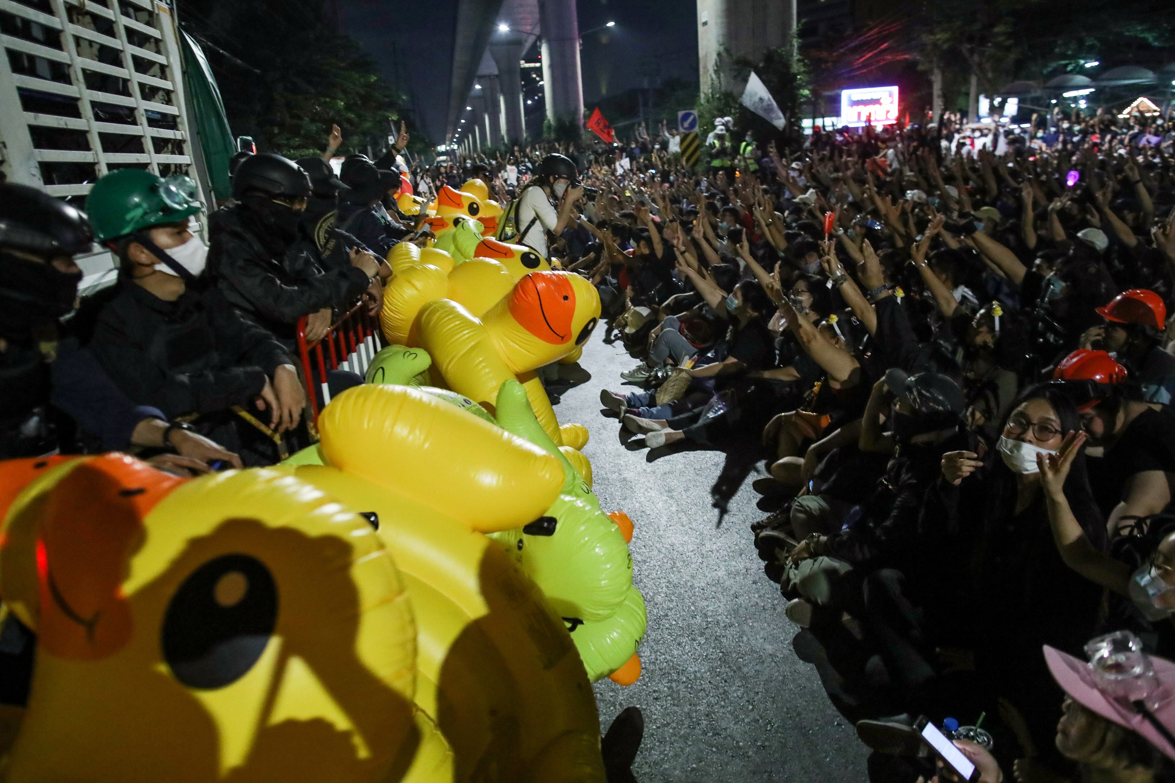 圖為11月29日，示威者遊行至曼谷一個軍營外示威，示威者在警方架設的防線外聚集。（Reuters）