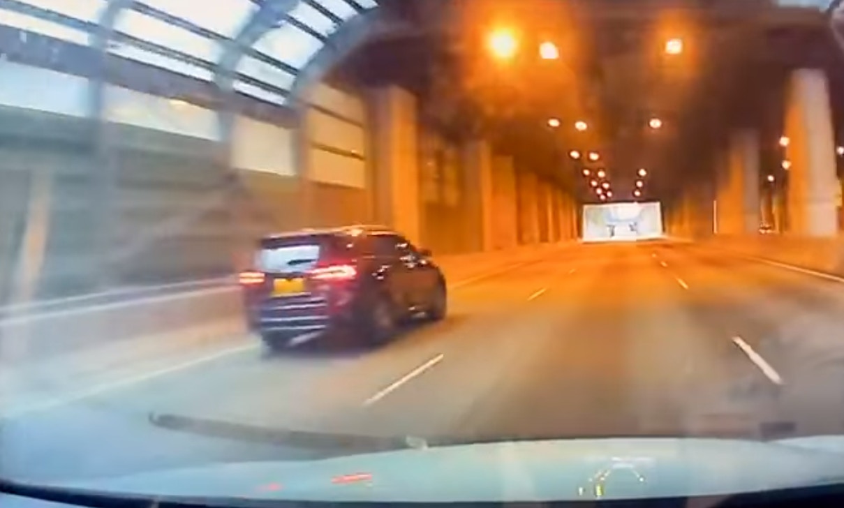 車CAM片段所見,一隻小貓疑似從一輛私家車內掉出來,貓咪在地上不停翻滾,後方司機見狀立即停車並救起牠。(影片截圖) 車CAM片段所見,一隻小貓疑似從一輛私家車內掉出來,貓咪在地上不停翻滾,後方司機見狀立即停車並救起牠。(影片截圖)