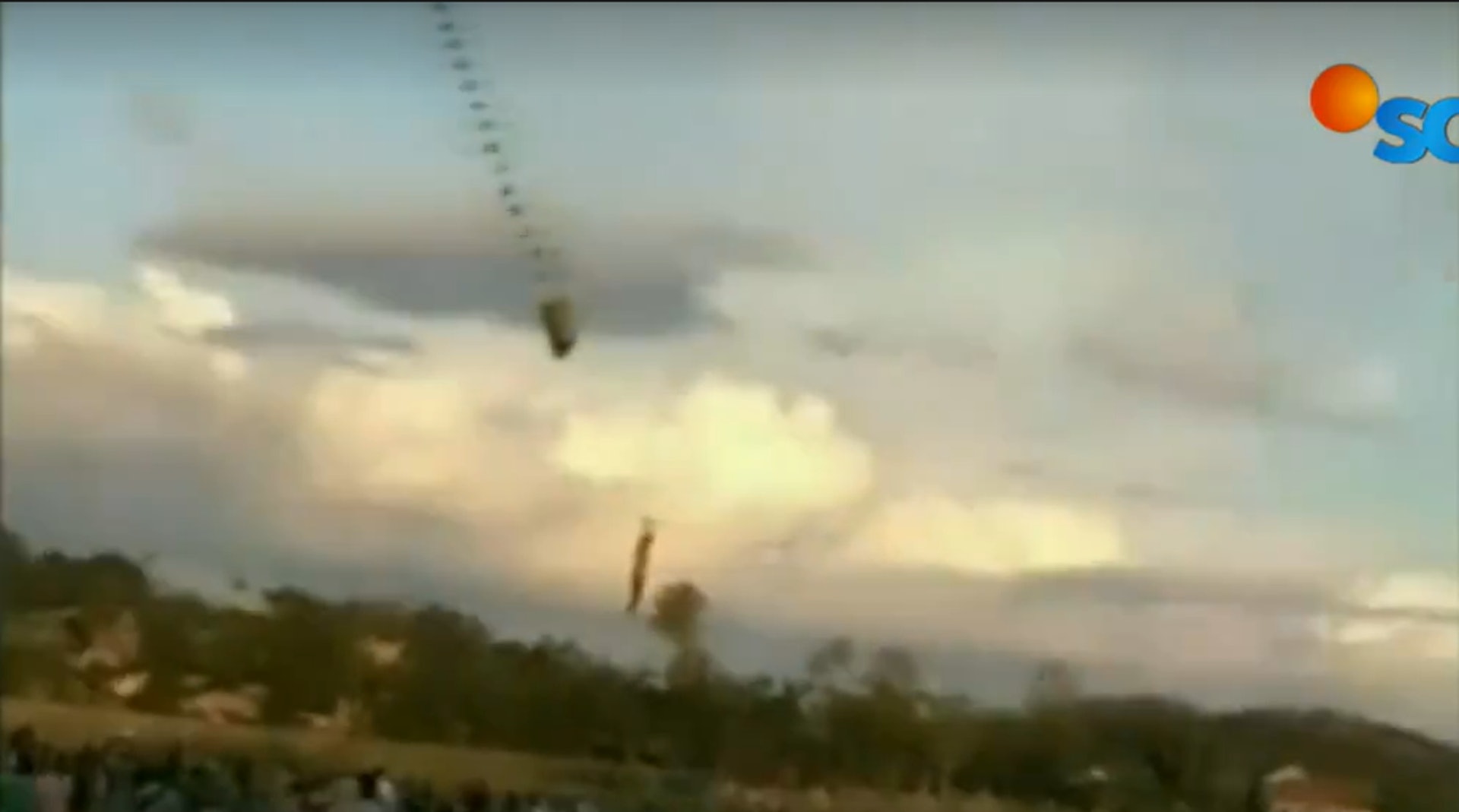 印尼男童放巨型的龍風箏，結果被風箏扯到半空中，下方草地有多人觀看。（SCTV新聞截圖）