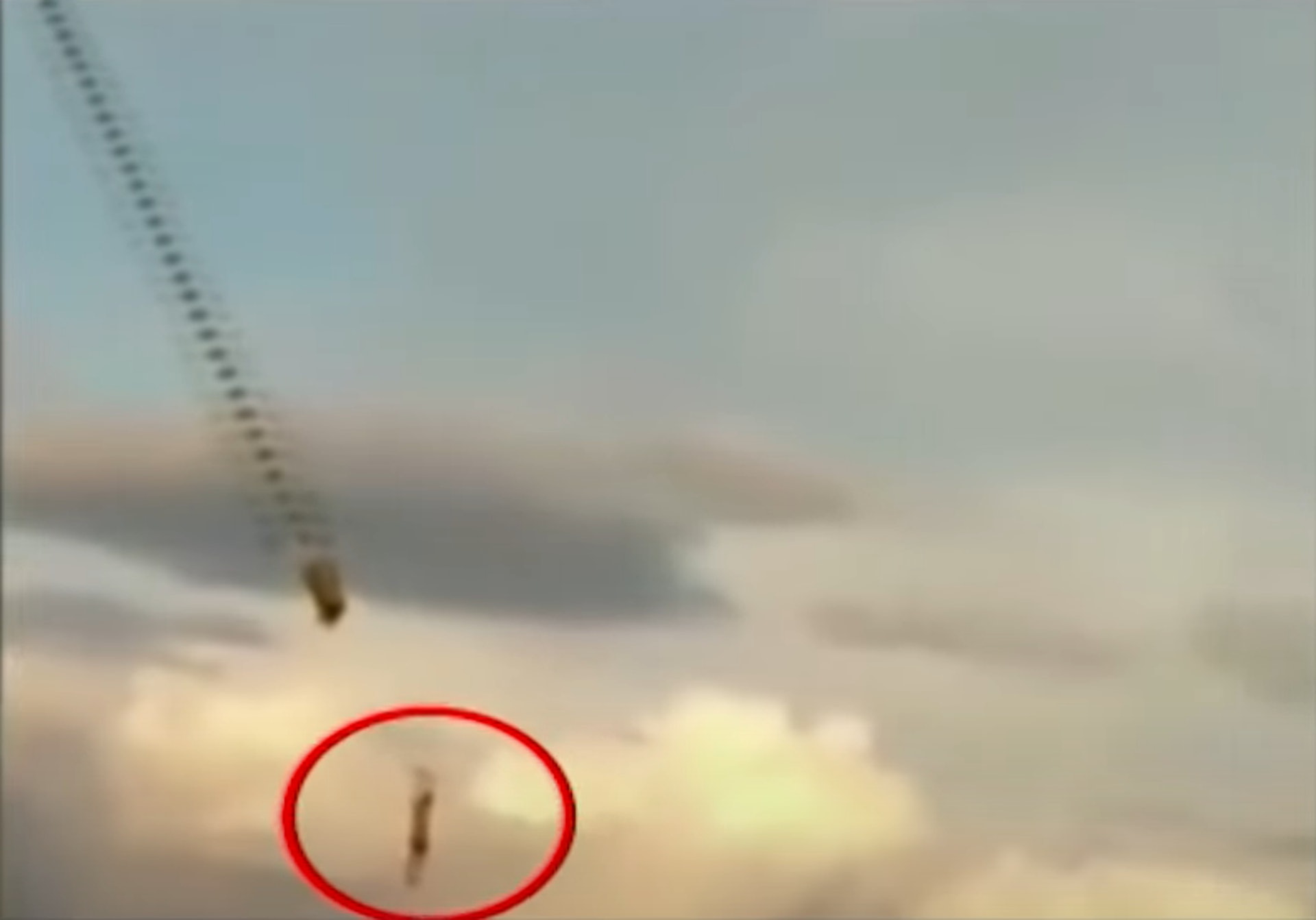 印尼男童放巨型的龍風箏，結果被風箏扯到半空中，下方草地有多人觀看。（SCTV新聞截圖）
