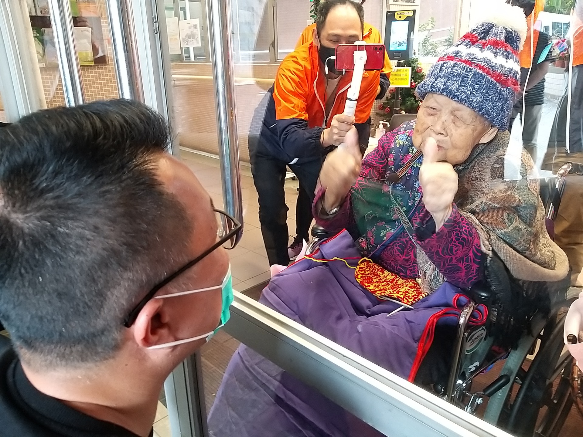 李小姐一家到院舍門口與陳婆婆隔門相敍。(黃穎津攝) 李小姐一家到院舍門口與陳婆婆隔門相敍。(黃穎津攝)