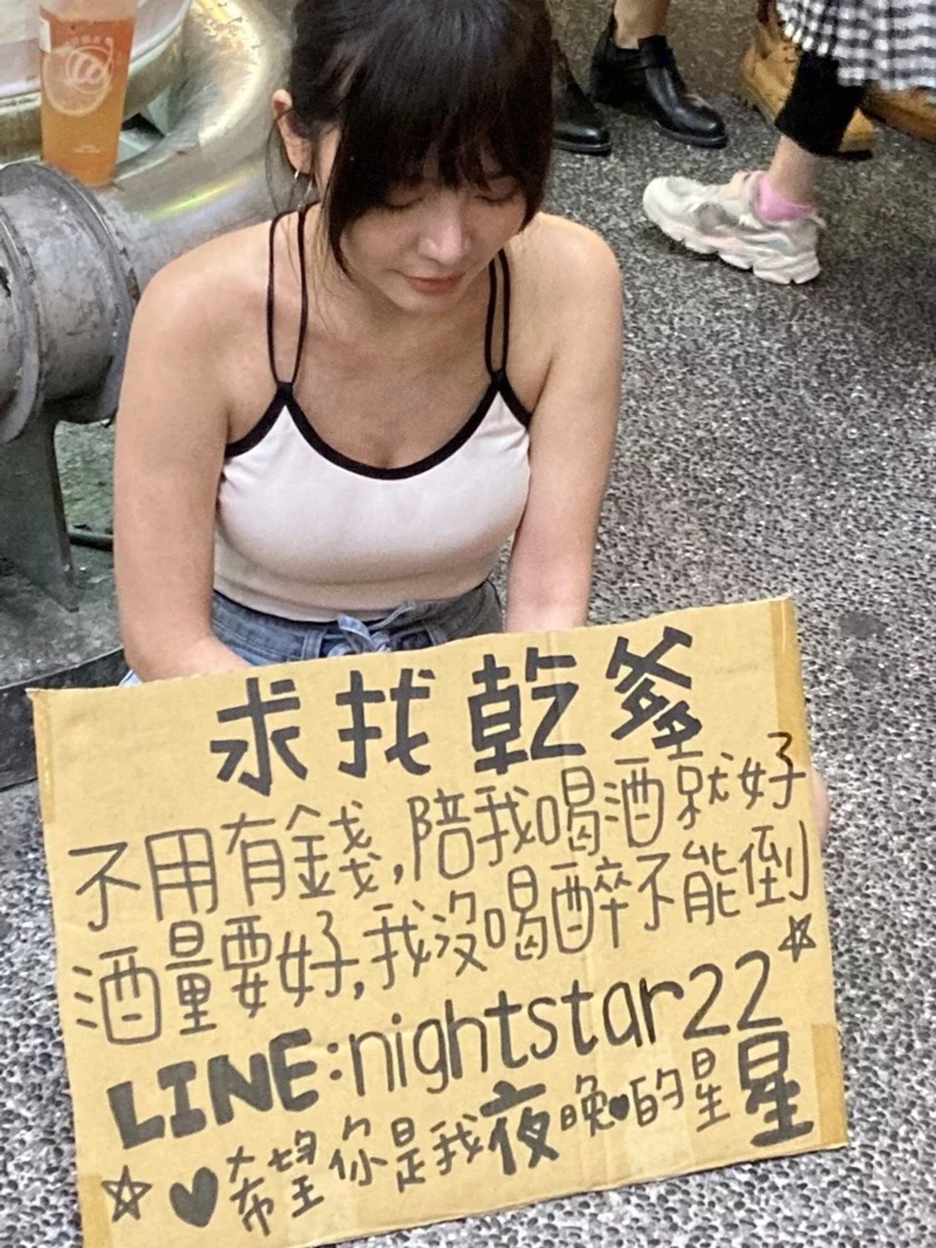 一名正妹坐在西門町,身前掛著「求找乾爹」厚紙板,引發網路及路過民眾的關注。(聯合新聞網提供) 一名正妹坐在西門町,身前掛著「求找乾爹」厚紙板,引發網路及路過民眾的關注。(聯合新聞網提供)