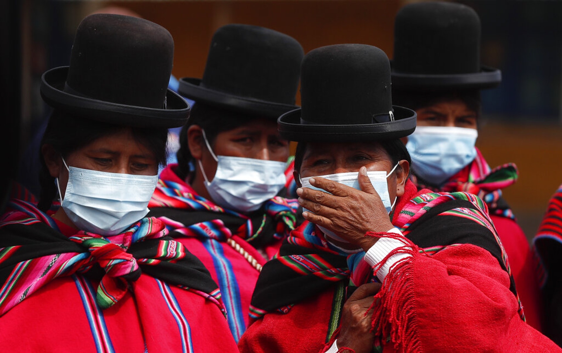 新冠肺炎疫情：圖為1月12日在玻利維亞蒂亞瓦納科，原住民族艾馬拉族婦女都戴上口罩，等待進入當地的0考古博物館。（AP）