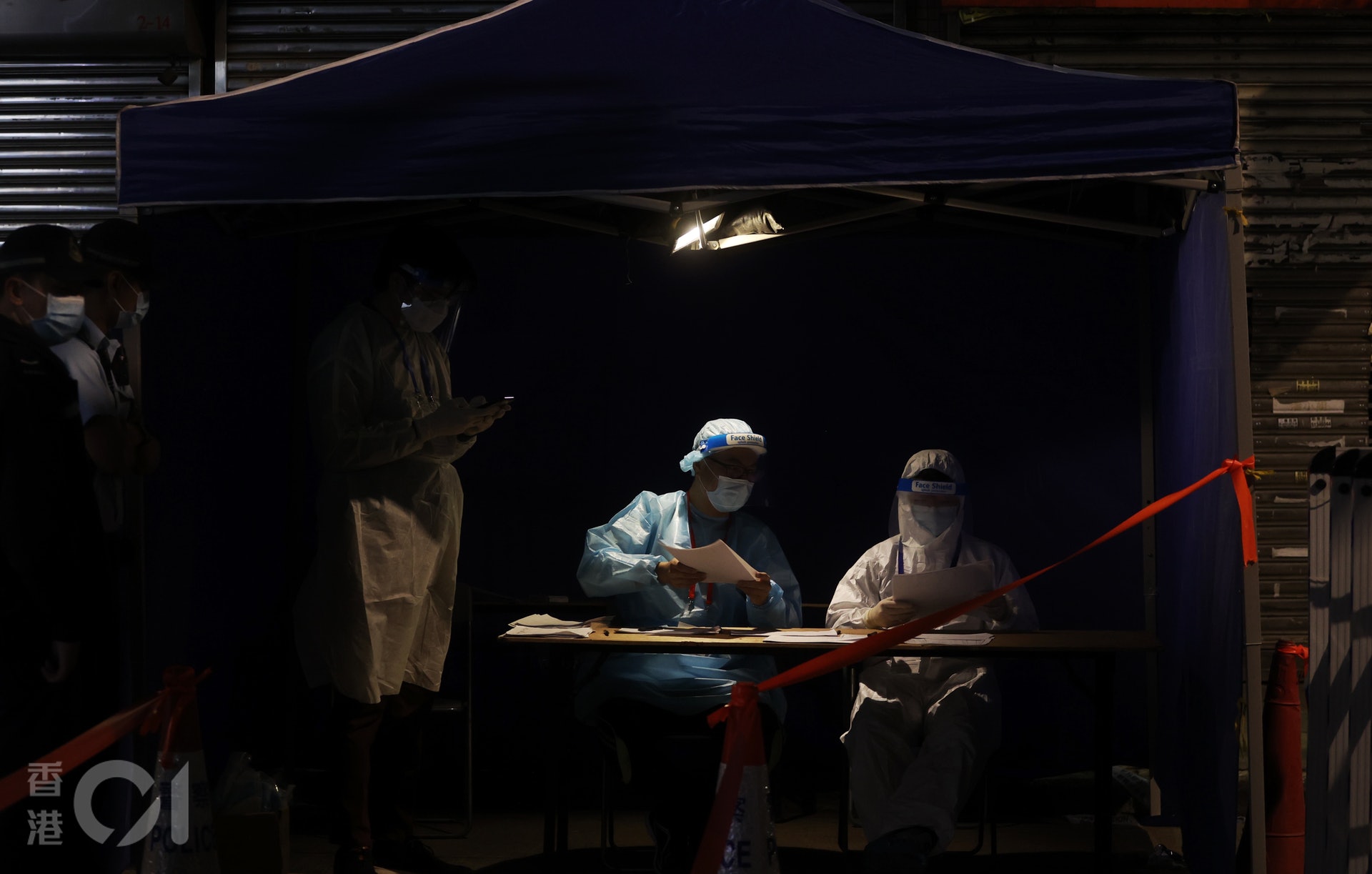 1月26日晚上約10時半，被圍封的碧街和東安街居民開始排隊做病毒檢測。（余俊亮攝）
