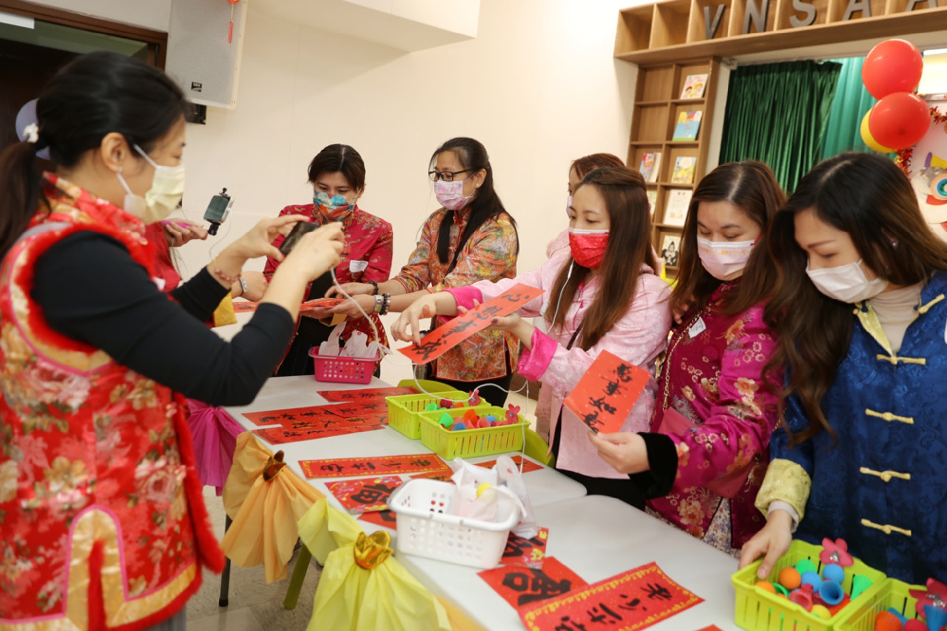 老師拿住電話,帶幼稚園學生行年宵。 老師拿住電話,帶幼稚園學生行年宵。
