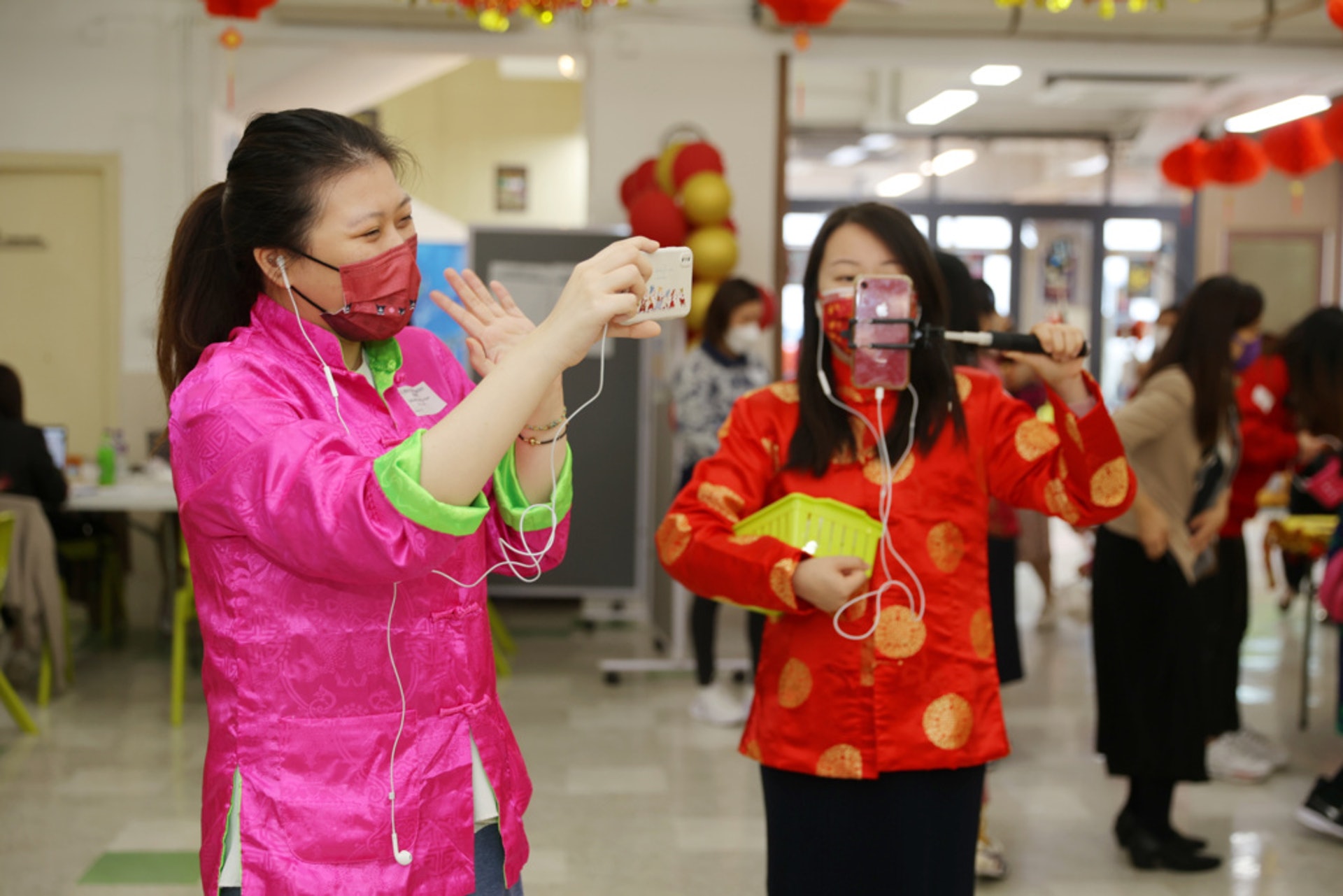 老師拿住電話,帶幼稚園學生行年宵。 老師拿住電話,帶幼稚園學生行年宵。