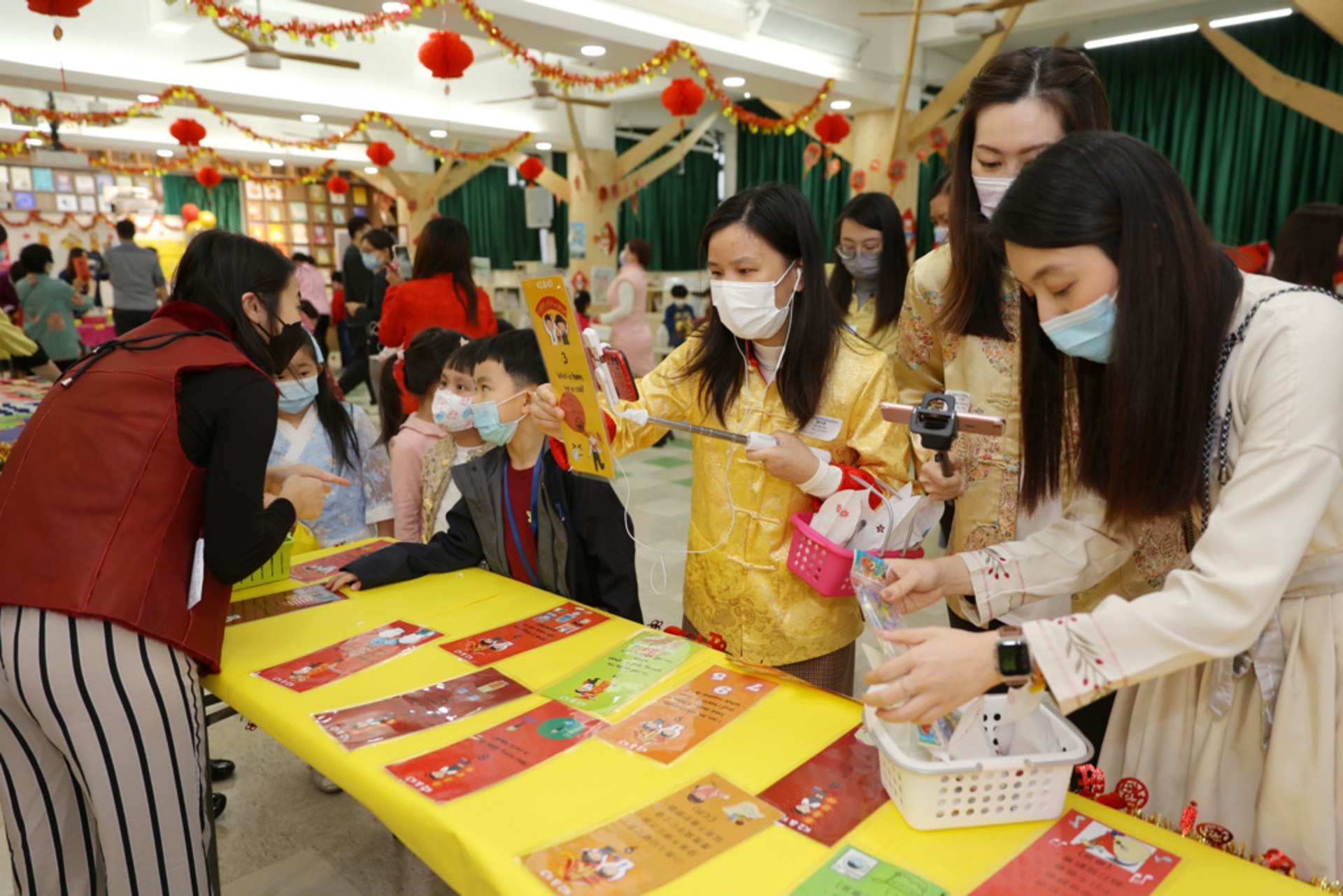 老師拿住電話,帶幼稚園學生行年宵。 老師拿住電話,帶幼稚園學生行年宵。
