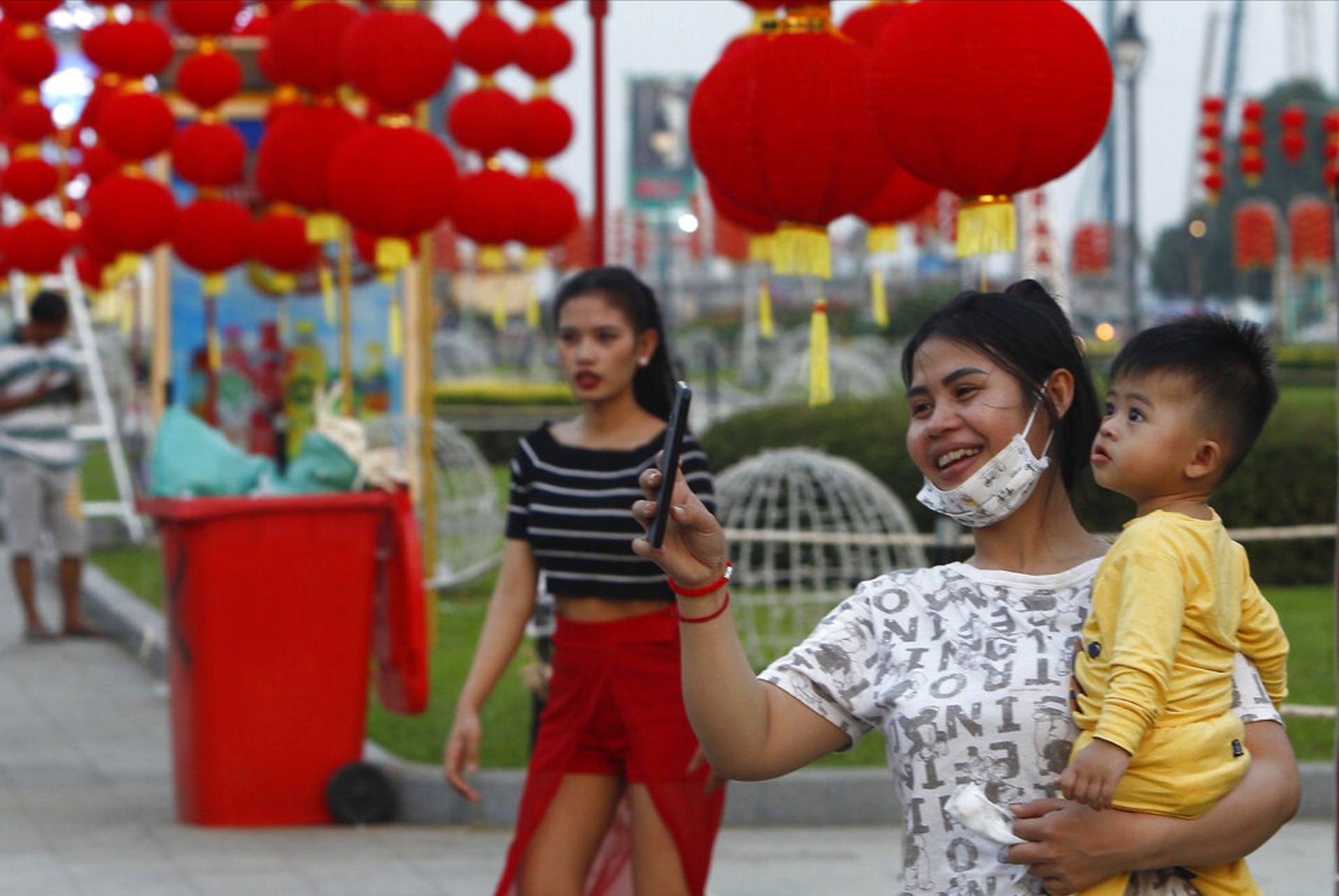 2021牛年:距離春節尚有一周,金邊市面的裝飾已甚具節日氣氛。圖為2月6日一名女子抱着一名幼童外出觀賞燈飾。(AP) 2021牛年:距離春節尚有一周,金邊市面的裝飾已甚具節日氣氛。圖為2月6日一名女子抱着一名幼童外出觀賞燈飾。(AP)