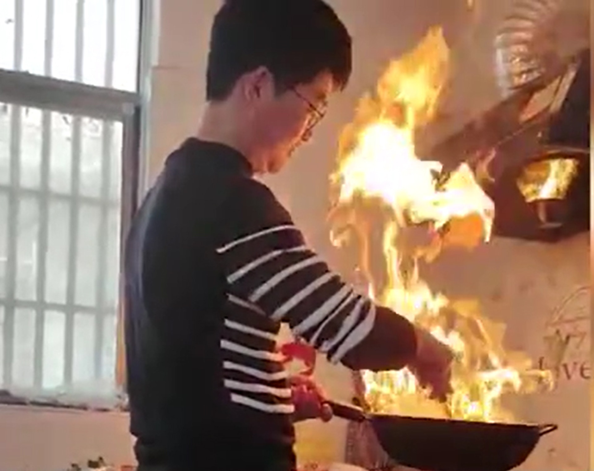 從影片可見,男子正把菜炒得如火如荼,火勢愈來愈旺,但他相當冷靜。(微博影片截圖) 從影片可見,男子正把菜炒得如火如荼,火勢愈來愈旺,但他相當冷靜。(微博影片截圖)