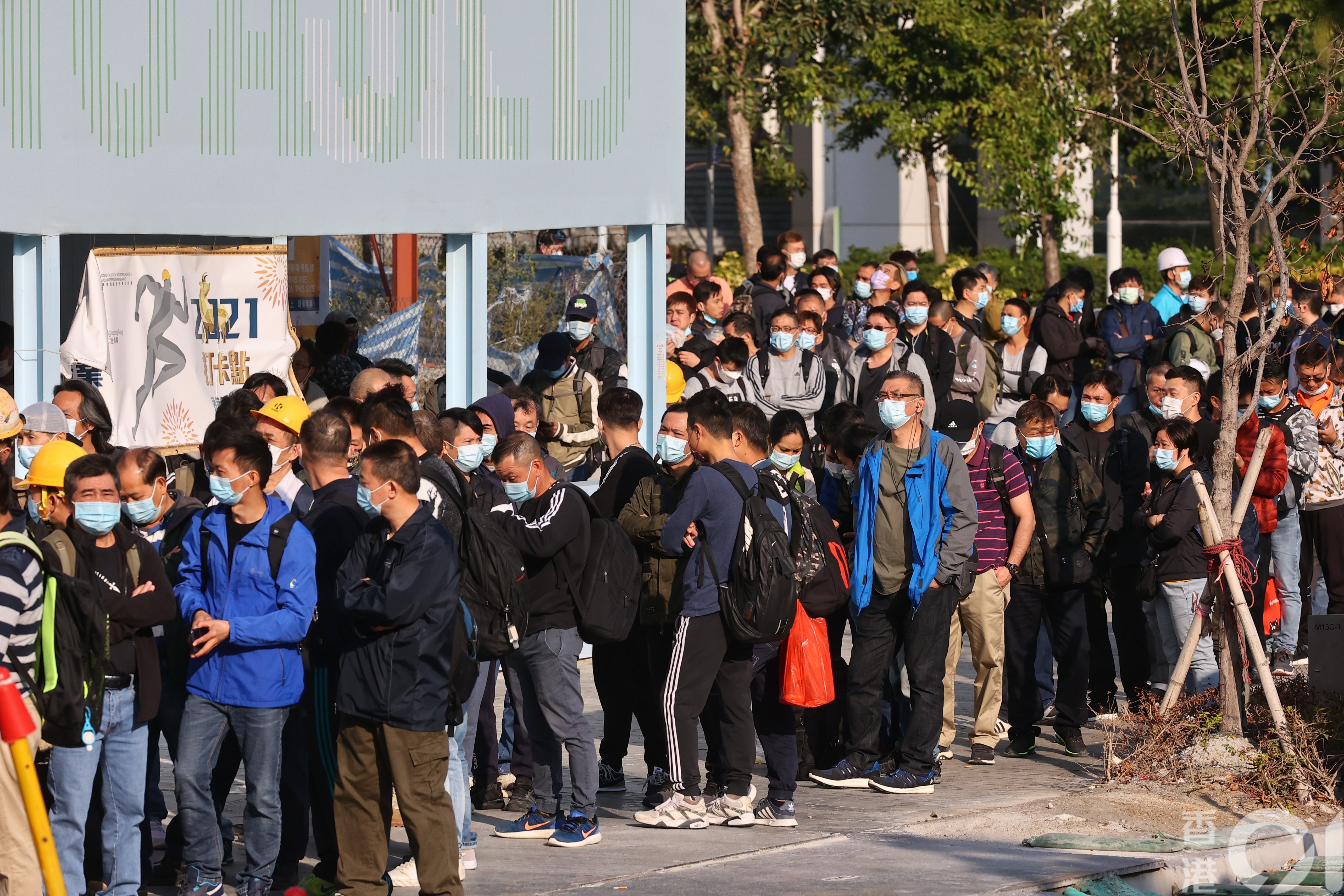 地盤林立的啟德一帶，今日有地盤外大排長龍，逾500名地盤工人及職員等候出示陰性檢測結果進入地盤工作。（張浩維攝）
