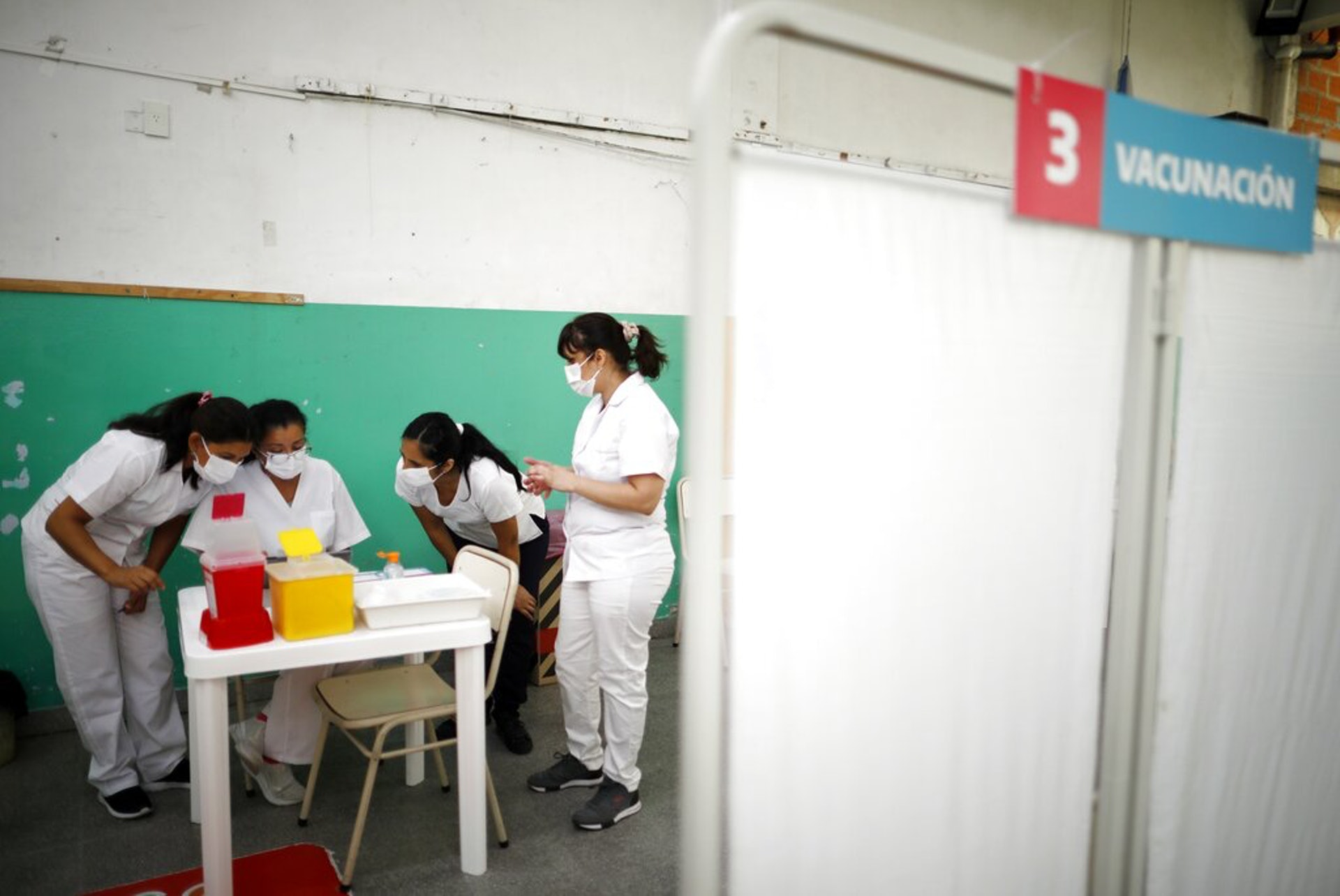 阿根廷新冠肺炎疫情：圖為2月18日，護士在布宜諾斯艾利斯一所公立學校內閱讀有關俄羅斯「衛星V」疫苗的注射指示。（AP）