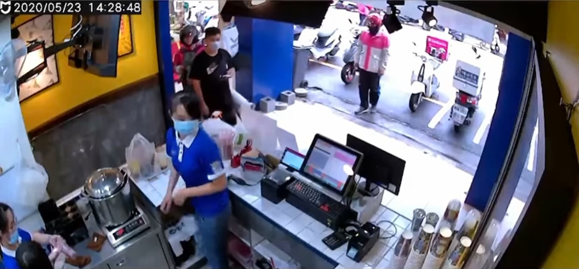 第一段畫面裡,一位熊貓外送員站在店外等餐時,在地上撿到200元,立即將錢交給店家櫃檯人員。(Facebook@外送員的奇聞怪事) 第一段畫面裡,一位熊貓外送員站在店外等餐時,在地上撿到200元,立即將錢交給店家櫃檯人員。(Facebook@外送員的奇聞怪事)