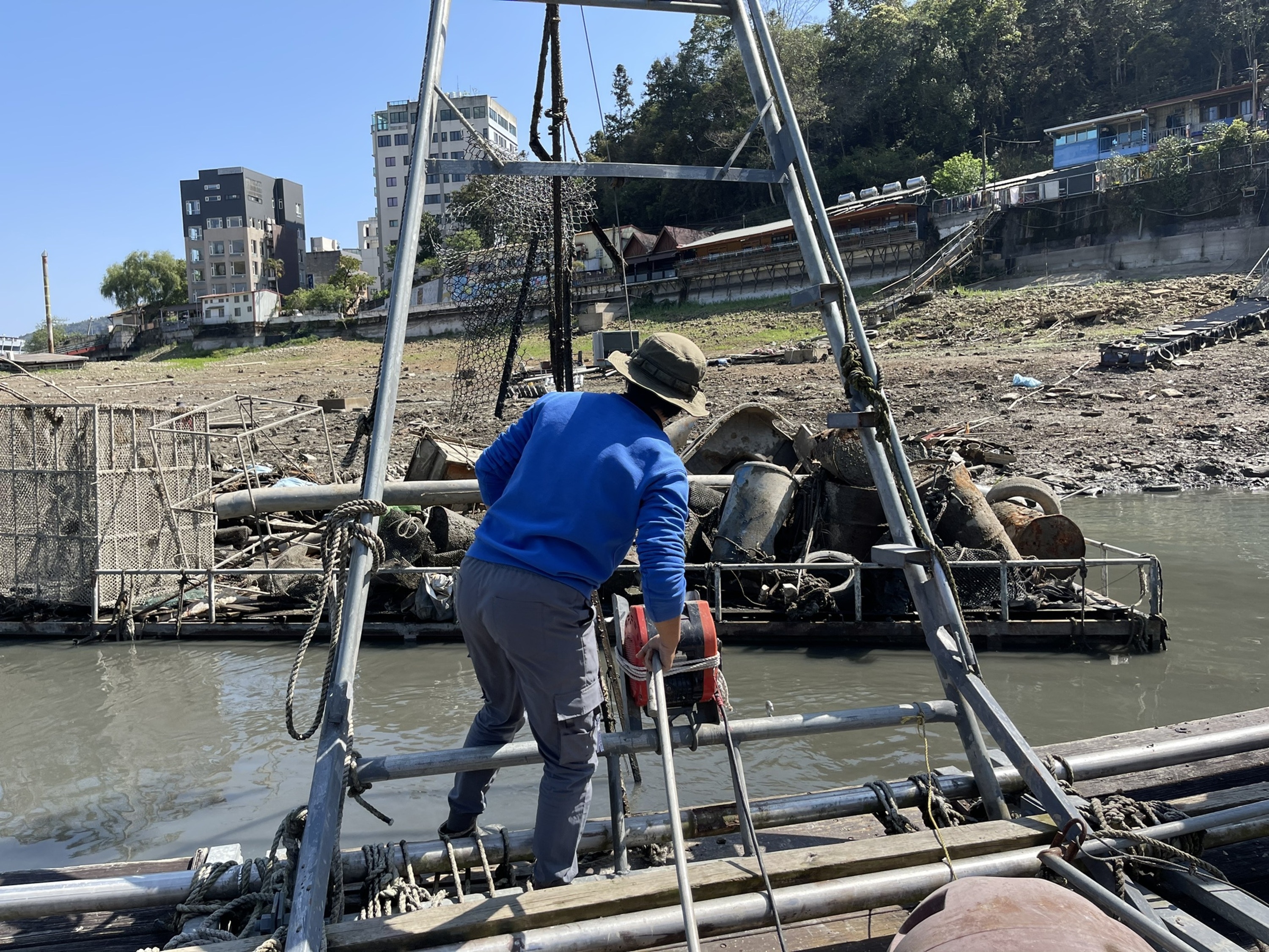 日月潭底的陳年垃圾如鐵桶、輪胎、漁具等陸續浮現，有當地漁民自發清除垃圾。（中央社）