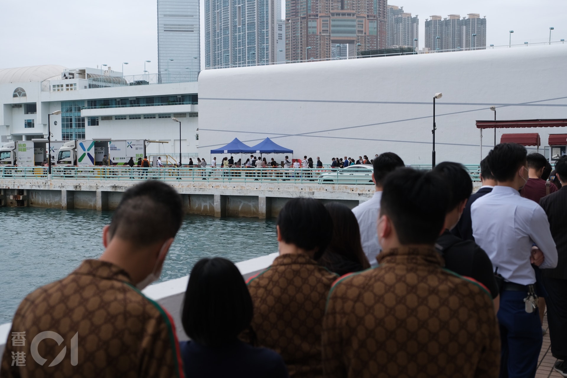海港城的流動採樣站觀察,發現逾百人沿著海邊排隊等候檢測,卻只得兩輛流動採樣車運作。(盧翊銘攝) 海港城的流動採樣站觀察,發現逾百人沿著海邊排隊等候檢測,卻只得兩輛流動採樣車運作。(盧翊銘攝)
