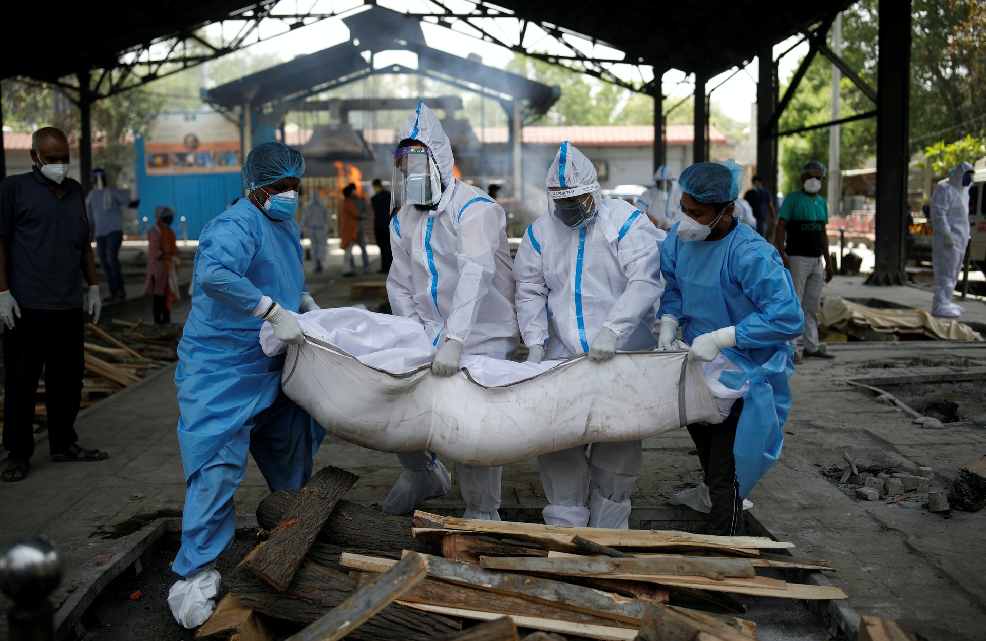 印度新冠肺炎疫情:圖為4月21日印度新德里醫療工作者和死者家屬在火葬場內搬運新冠肺炎病逝者遺體。(Reuters) 印度新冠肺炎疫情:圖為4月21日印度新德里醫療工作者和死者家屬在火葬場內搬運新冠肺炎病逝者遺體。(Reuters)