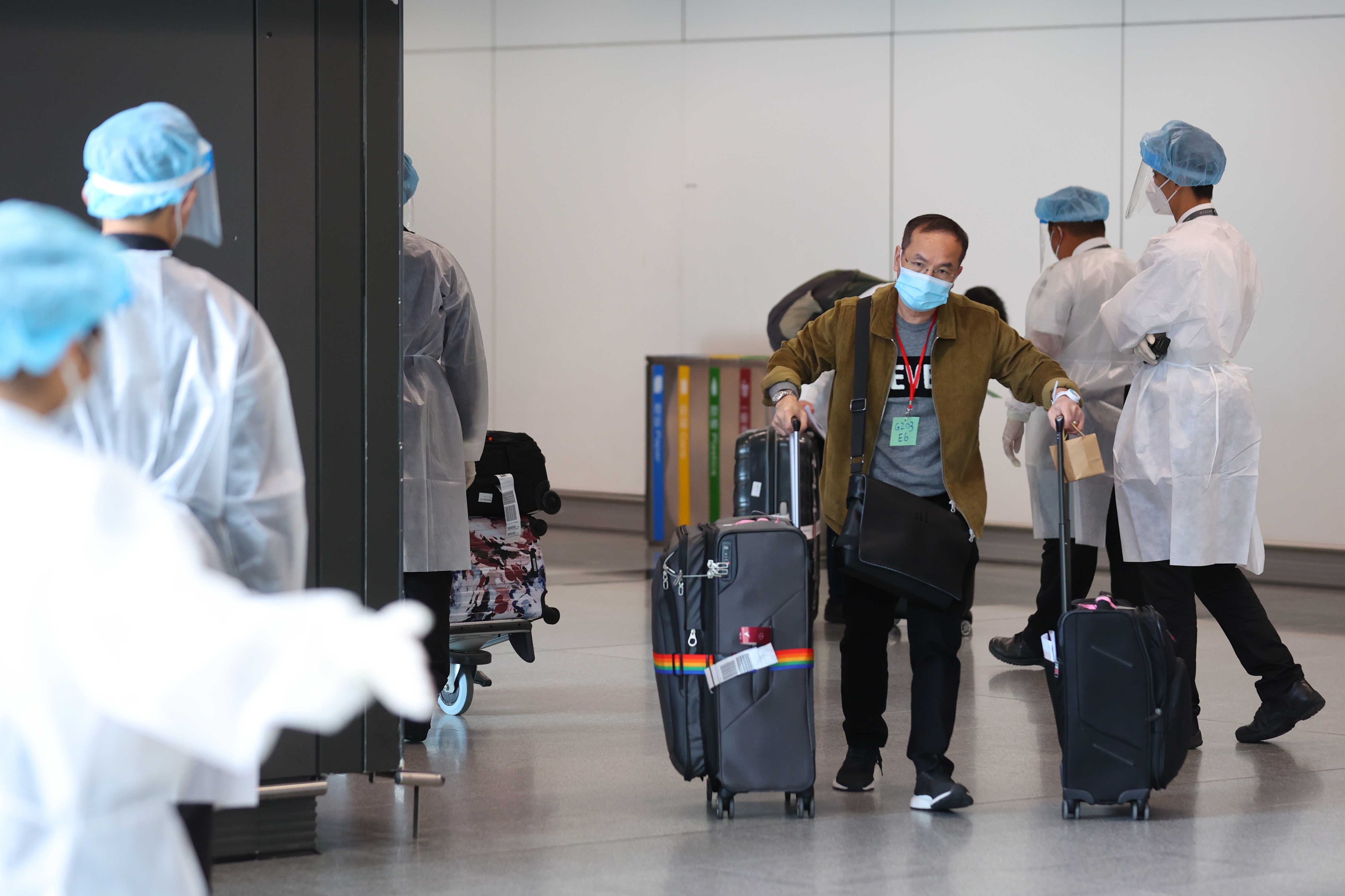 今早的接機大堂，機場人員均穿上全套防護裝備，核對入境港人資料，以及分流，不論是人手以及防疫程序均較周一菲律賓和印、巴航班禁飛前夕大為嚴謹。（羅君豪攝）