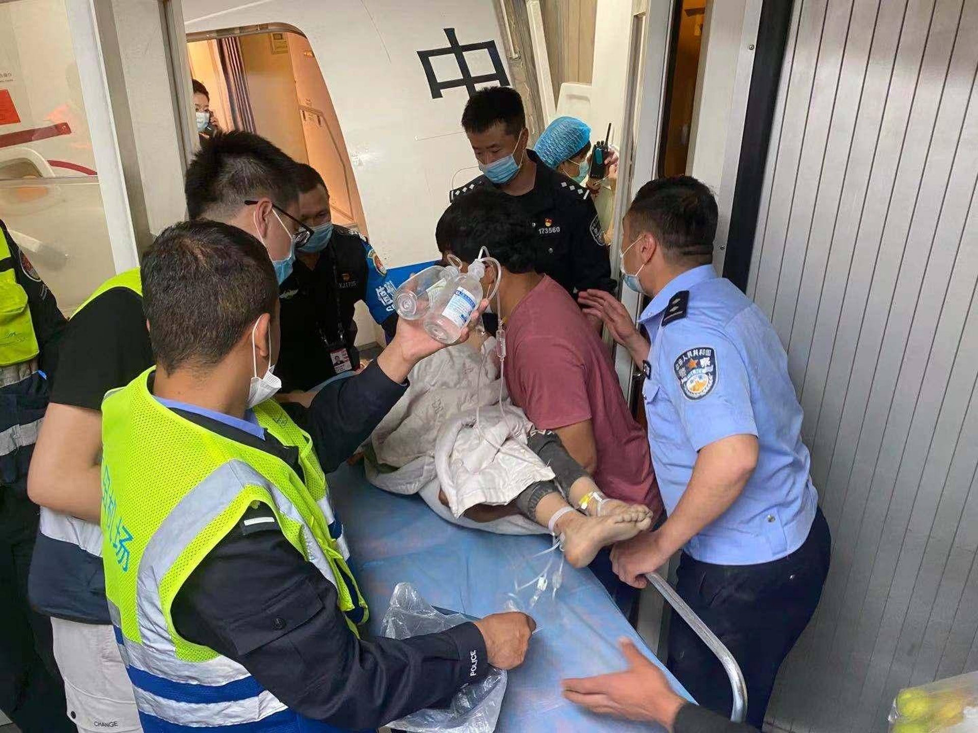 南航待飛航班從跑道折返登機口,機組人員協助男童等人登機。(南方都市報) 南航待飛航班從跑道折返登機口,機組人員協助男童等人登機。(南方都市報)