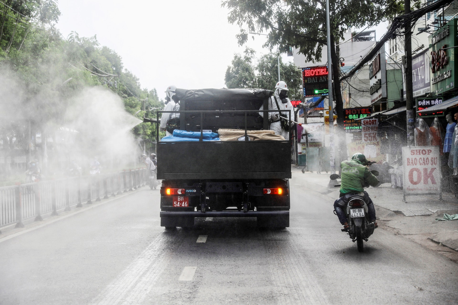越南新冠肺炎疫情：圖為6月1日越南胡志明市有人站在貨車上向路面噴灑消毒劑，鐵騎司機慘遭「照頭淋」。（Reuters）