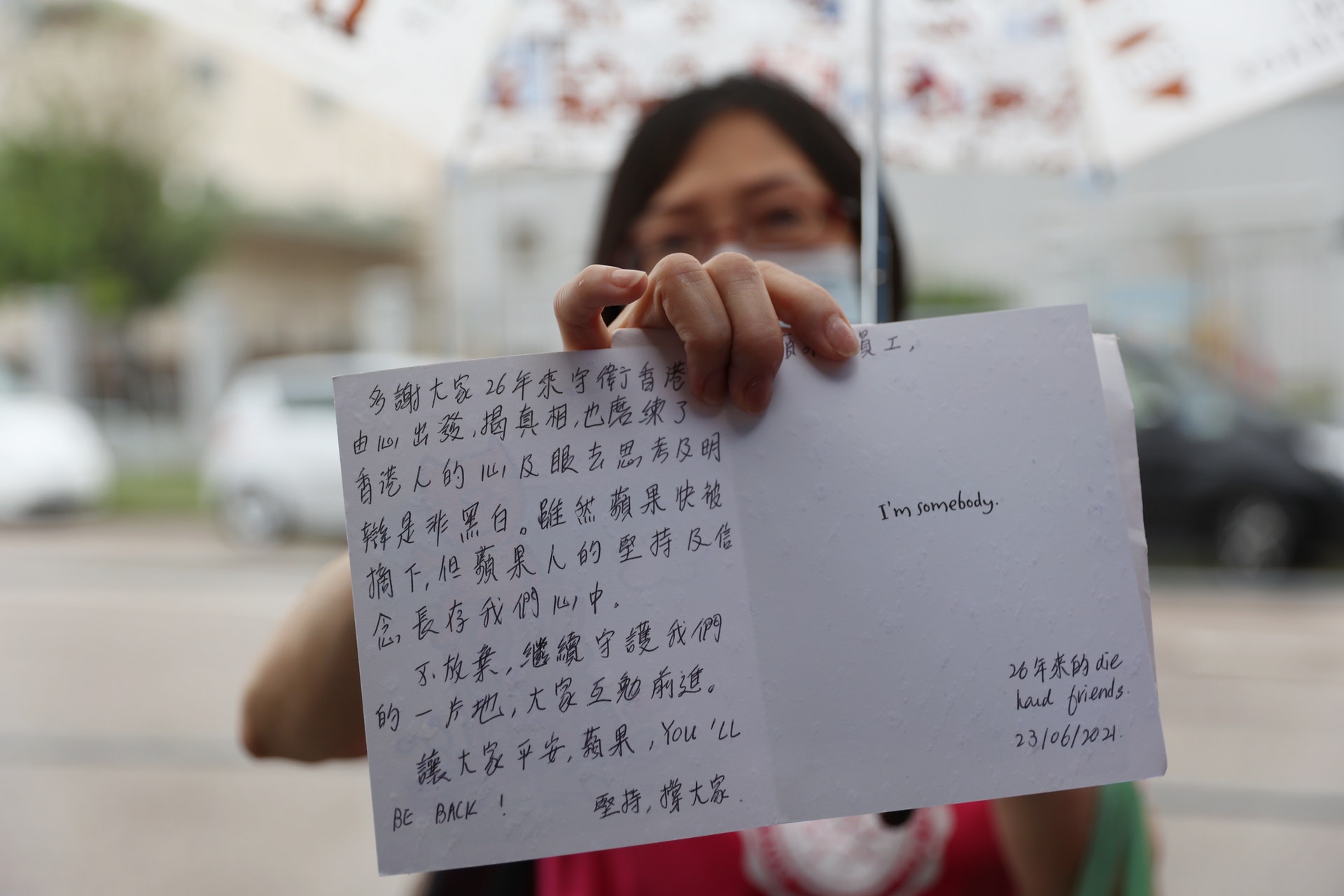 6月23日，市民譚小姐到壹傳媒大樓向員工獻花及送上心意卡以示支持。(鄭子峰攝）