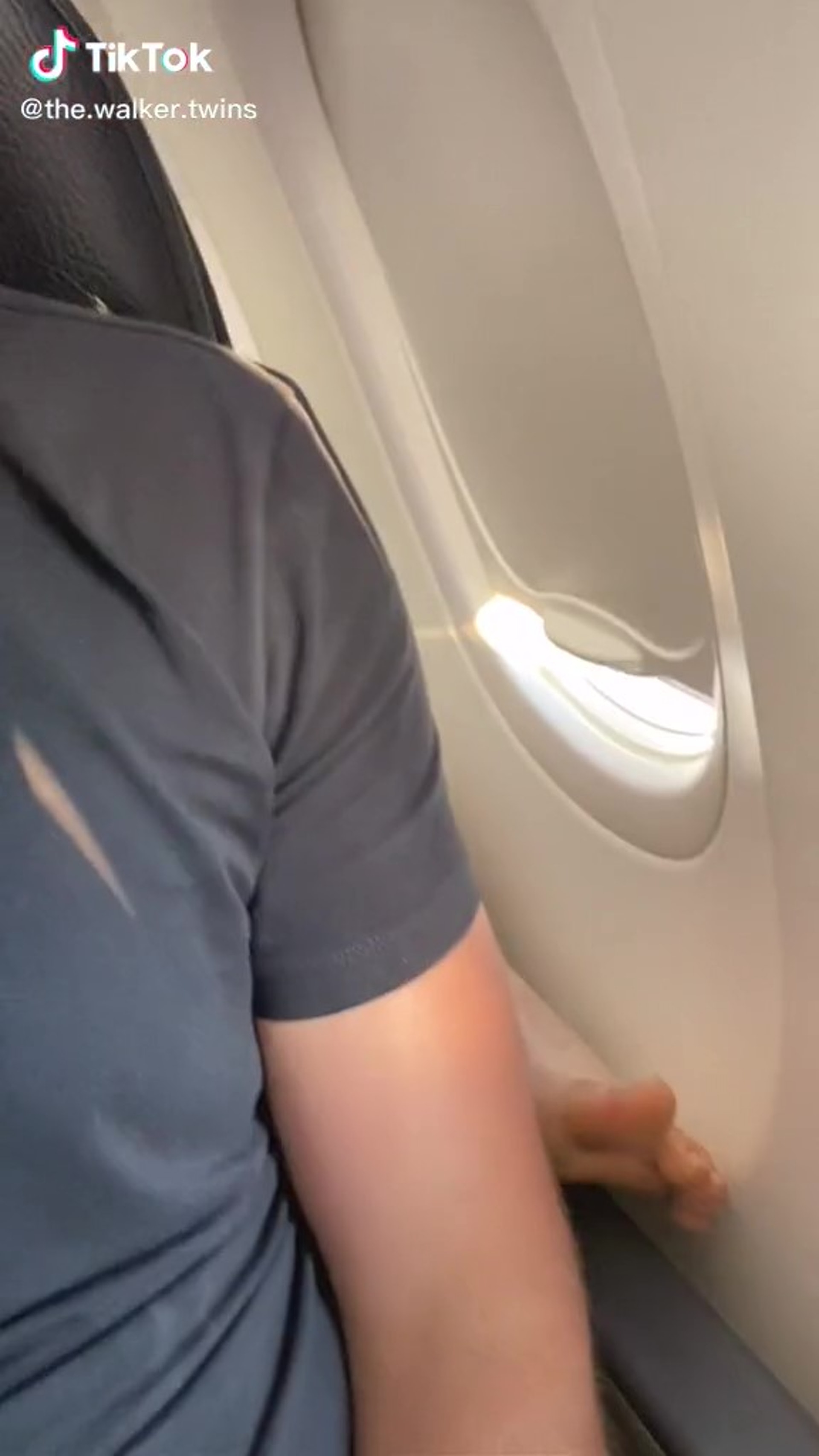 靚仔網紅坐飛機時發現後座乘客把光溜溜的腳板伸至其座位扶手上，令他非常不滿。（tiktok「the.walker.twins」影片截圖）
