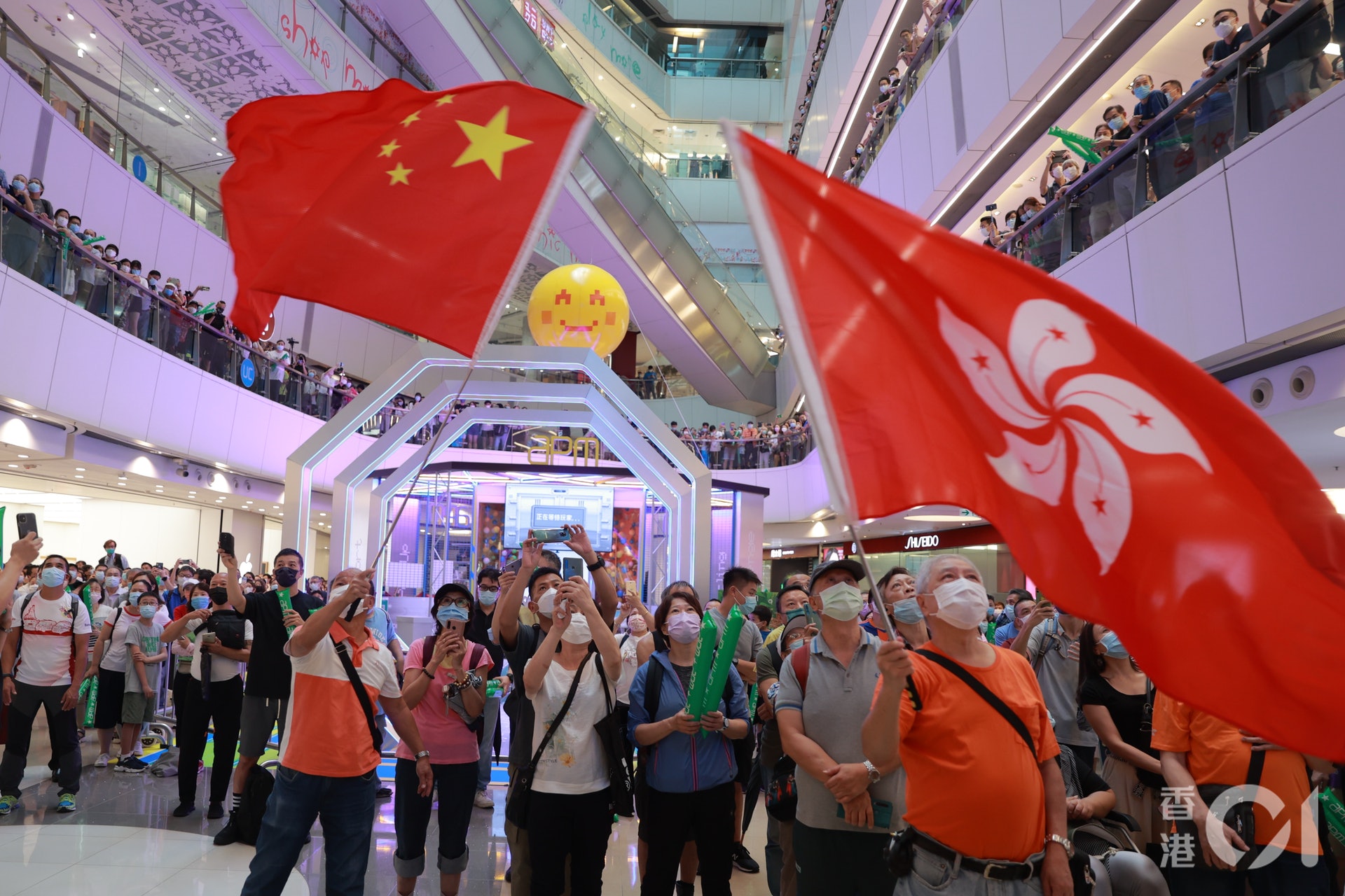 今早大批市民到觀塘APM觀看奧運賽事,有兩名身穿橙色衫的男子在場分別揮中國國旗及香港區旗。(羅國輝攝) 今早大批市民到觀塘APM觀看奧運賽事,有兩名身穿橙色衫的男子在場分別揮中國國旗及香港區旗。(羅國輝攝)