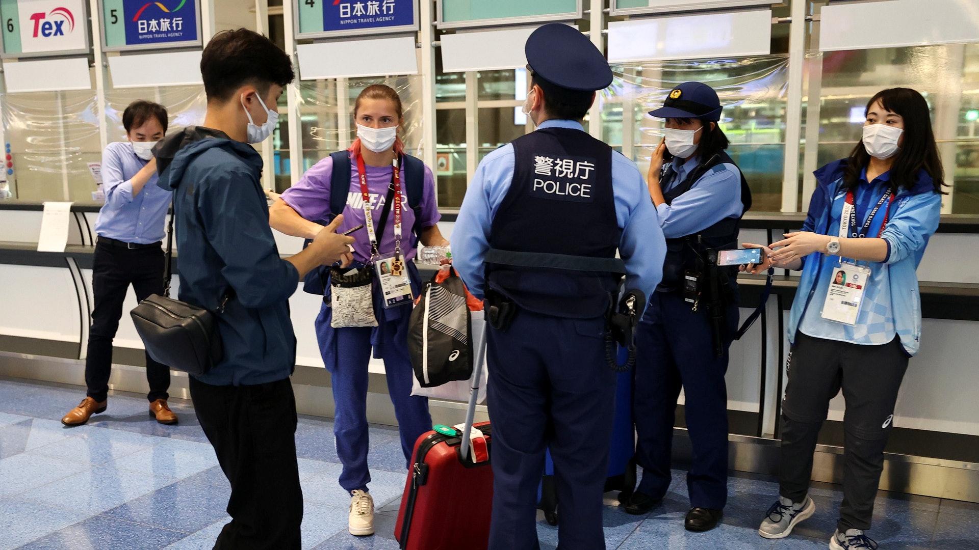 東京奧運:圖為8月1日,白羅斯女跑手齊馬諾斯卡雅(紫衣者)在東京羽田機場獲警員護送。(Reuters) 東京奧運:圖為8月1日,白羅斯女跑手齊馬諾斯卡雅(紫衣者)在東京羽田機場獲警員護送。(Reuters)