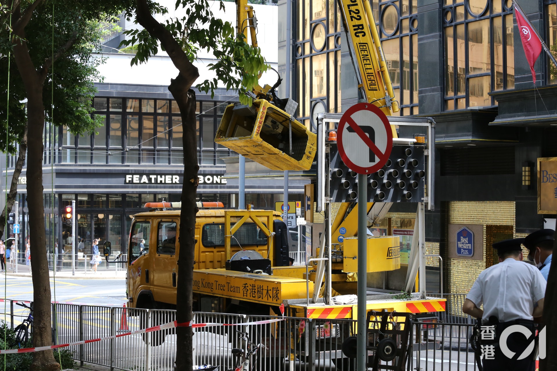 今日(18日)早上9時許,西環水街及第三街交界路段,兩名康文署職員登上升降台,在離地10米高位置修剪樹木。(翁鈺輝攝)